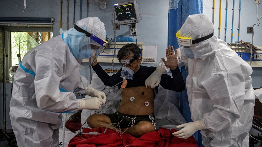 Medical workers tend to a coronavirus patient in the intensive care unit at Lok Nayak Jai Prakash Hospital in New Delhi