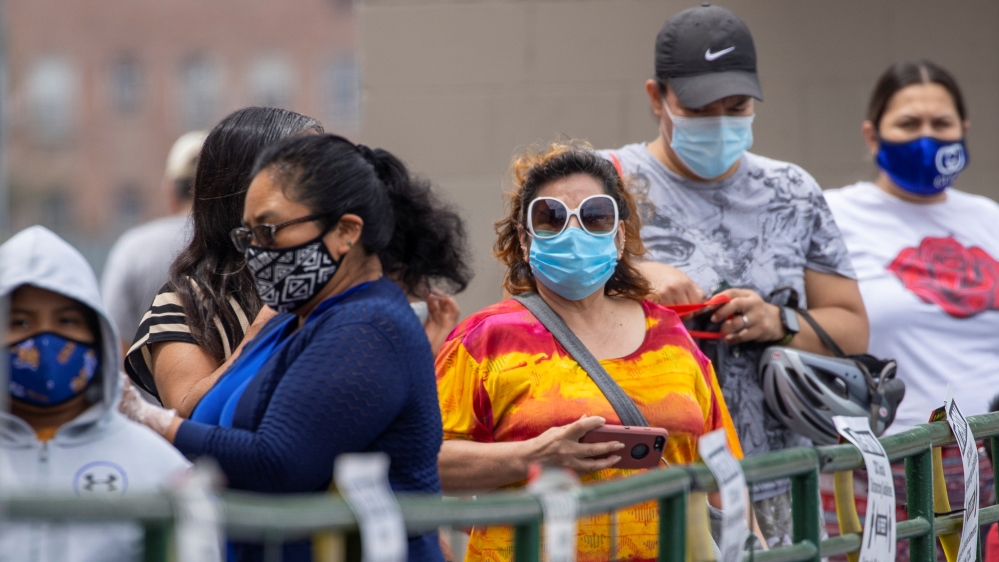 Customers wait in line to shop for food at a Food 4 Less grocery store during the outbreak of the coronavirus disease in Los Angeles, California, in August