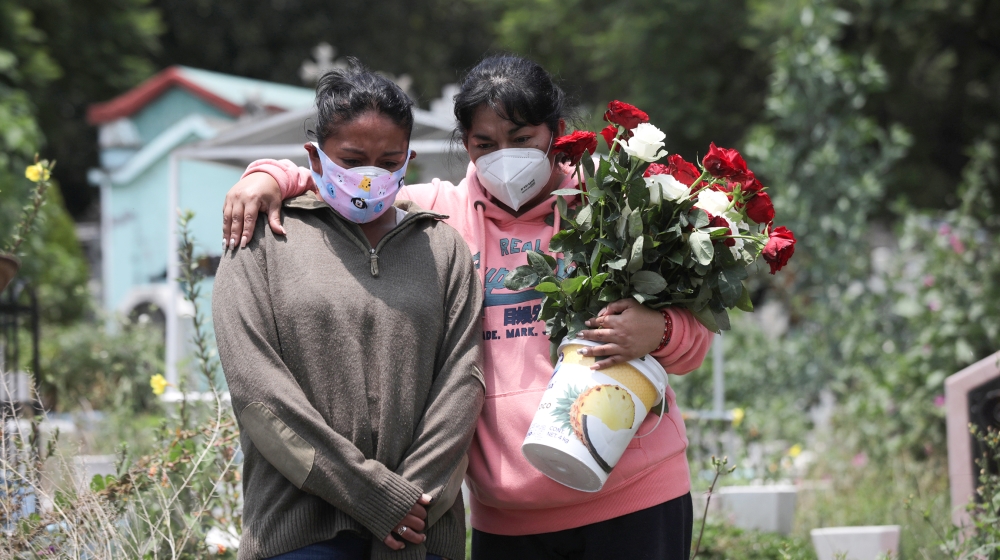 Relatives react near the coffin of a man, during his funeral at the local cemetery, as the coronavirus disease (COVID-19) outbreak continues in Mexico City, Mexico, August 6, 2020. REUTERS/Henry Romer