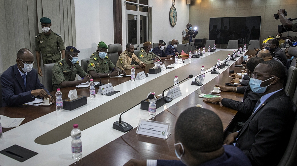 Representatives of the National Committee for the Salvation of the People, left of table, including Col. Assimi Goita, center of row, who has declared himself the group''s leader, meet with a high-leve