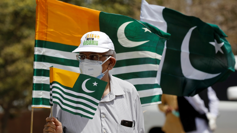 A man in Pakistani city of Karachi holds a flag as he observes a one-minute silence with others to mark the ‘Day of Exploitation in Kashmir’, one year after the Indian government stripped Kashmir of its autonomy