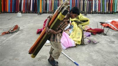 A 13-year-old boy in Hyderabad carries cloth for dyeing