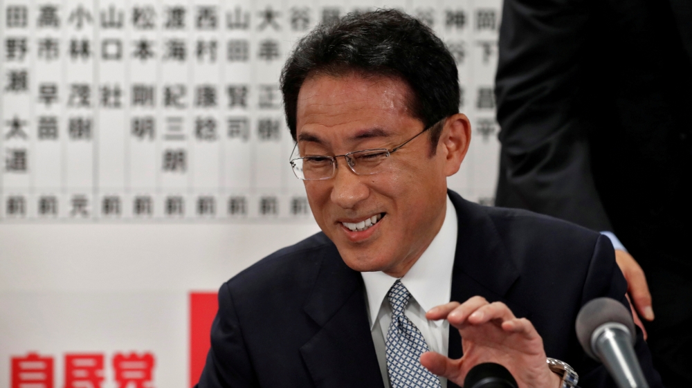 Japan's ruling Liberal Democratic Party policy chief Fumio Kishida smiles as he speaks with the media after Japan's lower house election at the LDP headquarters in Tokyo