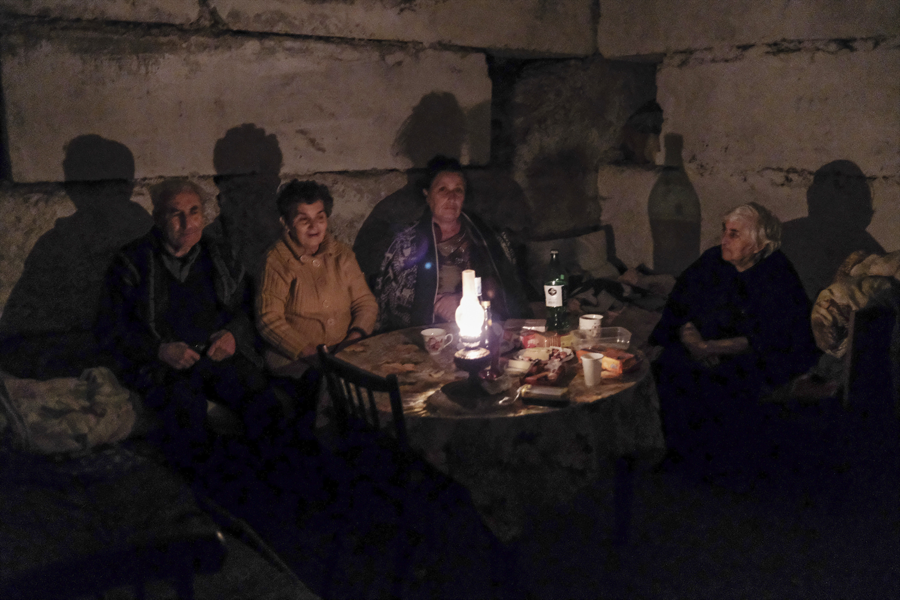 People sit in a bomb shelter during a military conflict in the city of Stepanakert, the breakaway region of Nagorno-Karabakh in Azerbaijan on October 5, 2020 [Areg Balayan/ArmGov PAN Photo via AP]