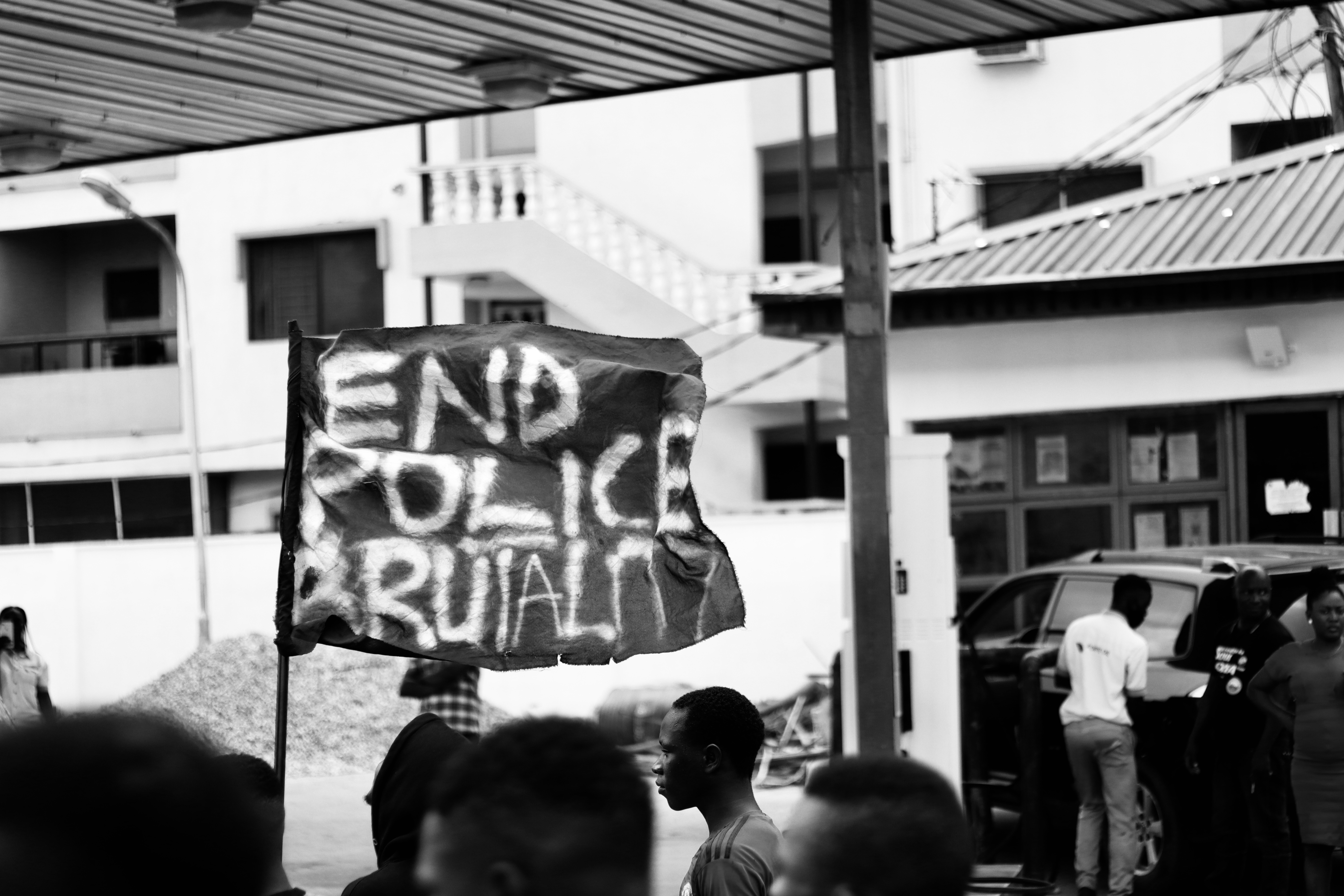 Protesters raise a flag during a march through the Lagos district of Surulere. Mostly peaceful protests calling for an end to police brutality have sprung up in many Nigerian cities [Adedamola Odetara/Al Jazeera]