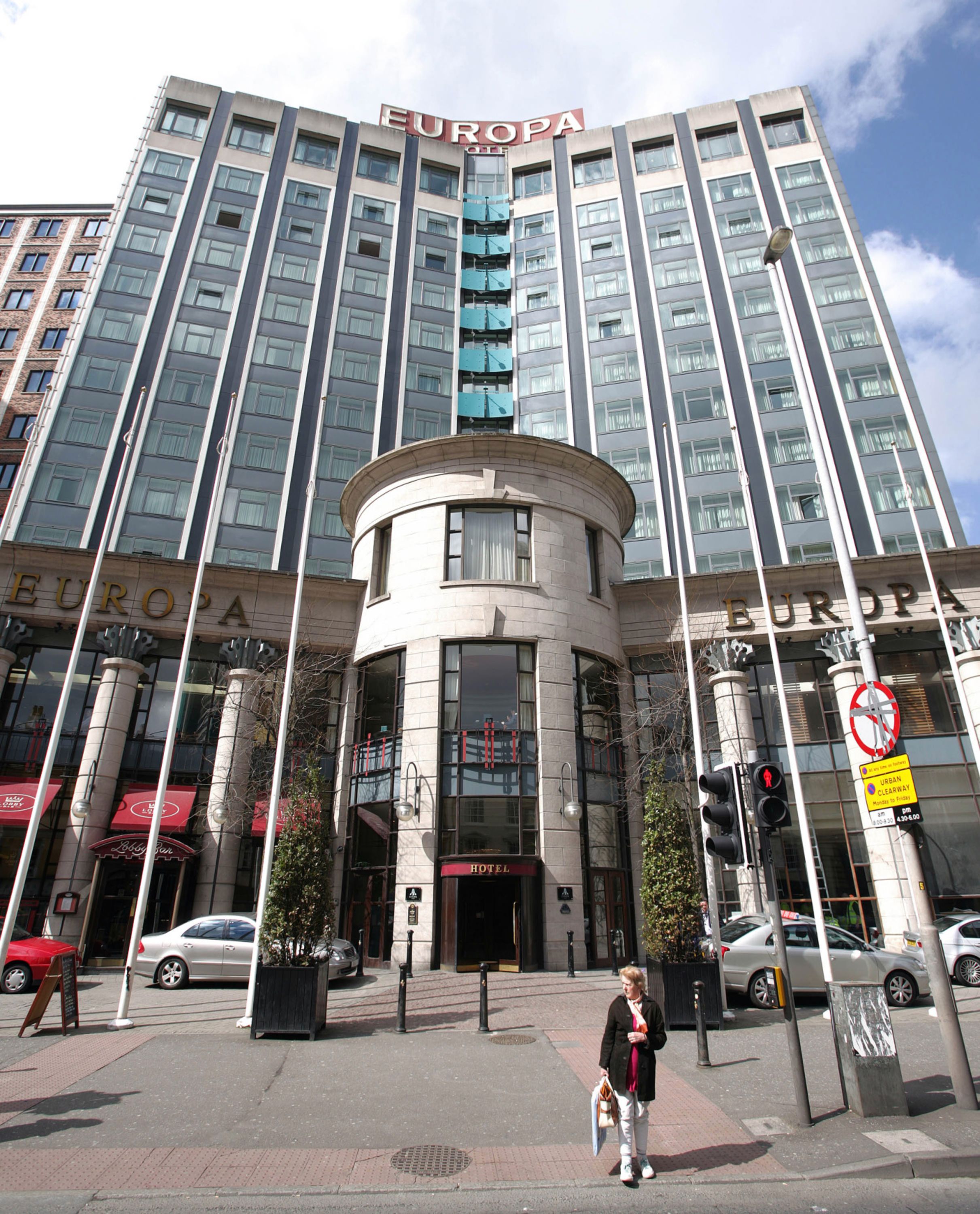 Pedestrians walk in front of the Europa Hotel in Belfast on April 29, 2008