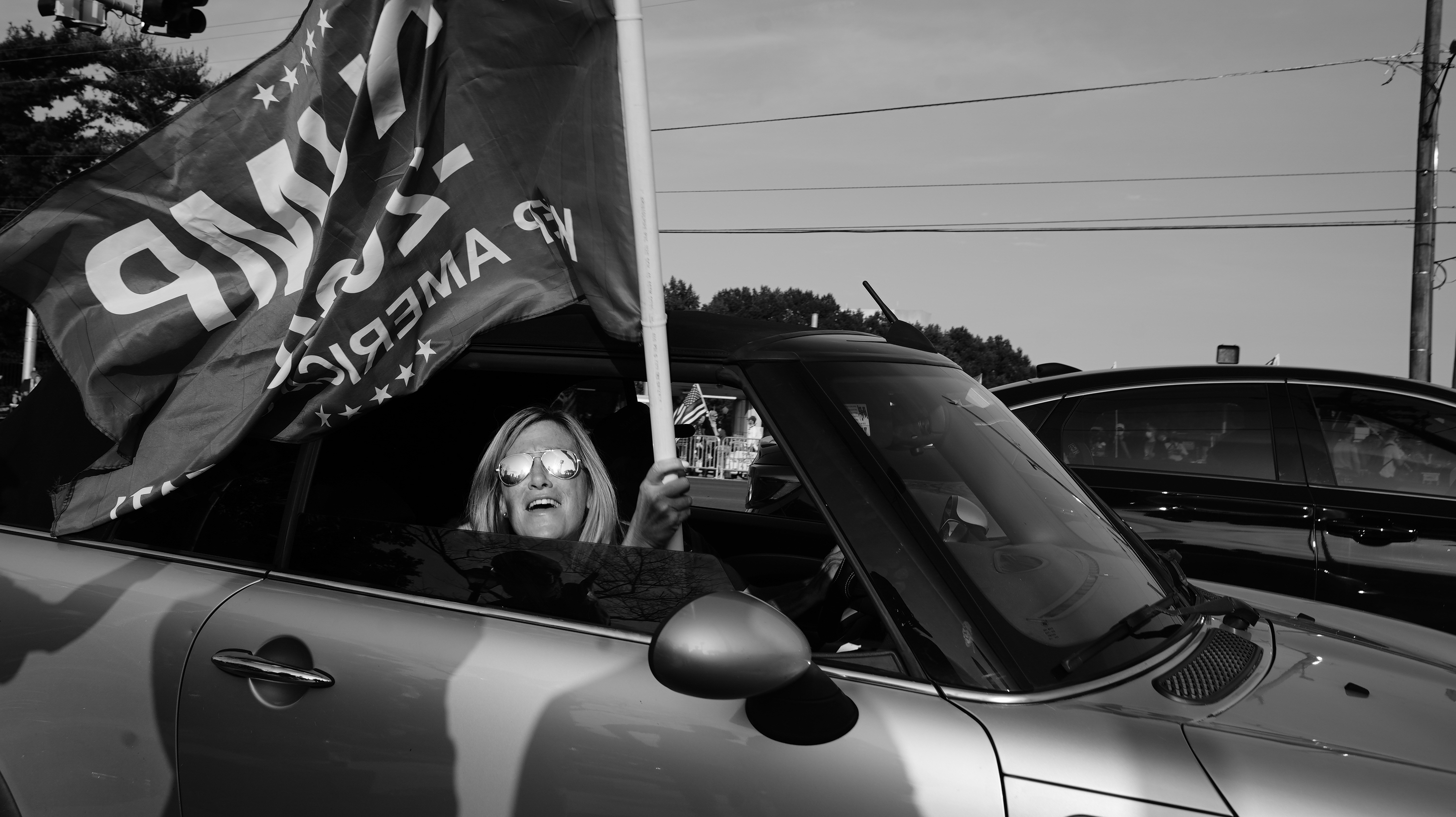 A Donald Trump fan drives by Walter Reed Medical Centre in Bethesda, Maryland on October 4 [Josh Rushing/Al Jazeera]