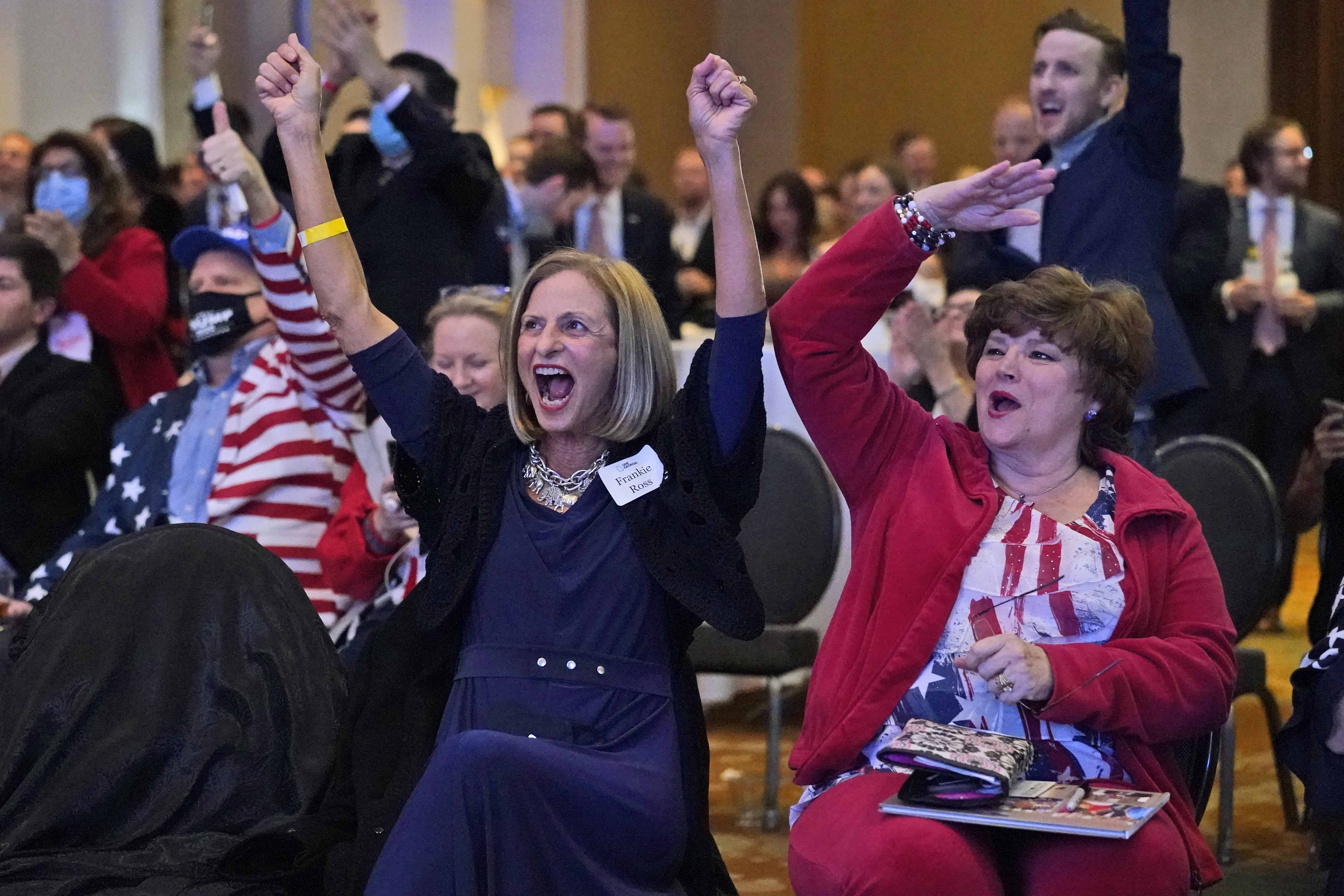 Frankie Ross, center, a supporter of Republican candidate for Senate U.S. Sen. David Perdue, cheer as Fox News called Florida for President Trump during an election-night watch party Tuesday Nov. 3, 2020 in Atlanta. (AP Photo/John Bazemore)