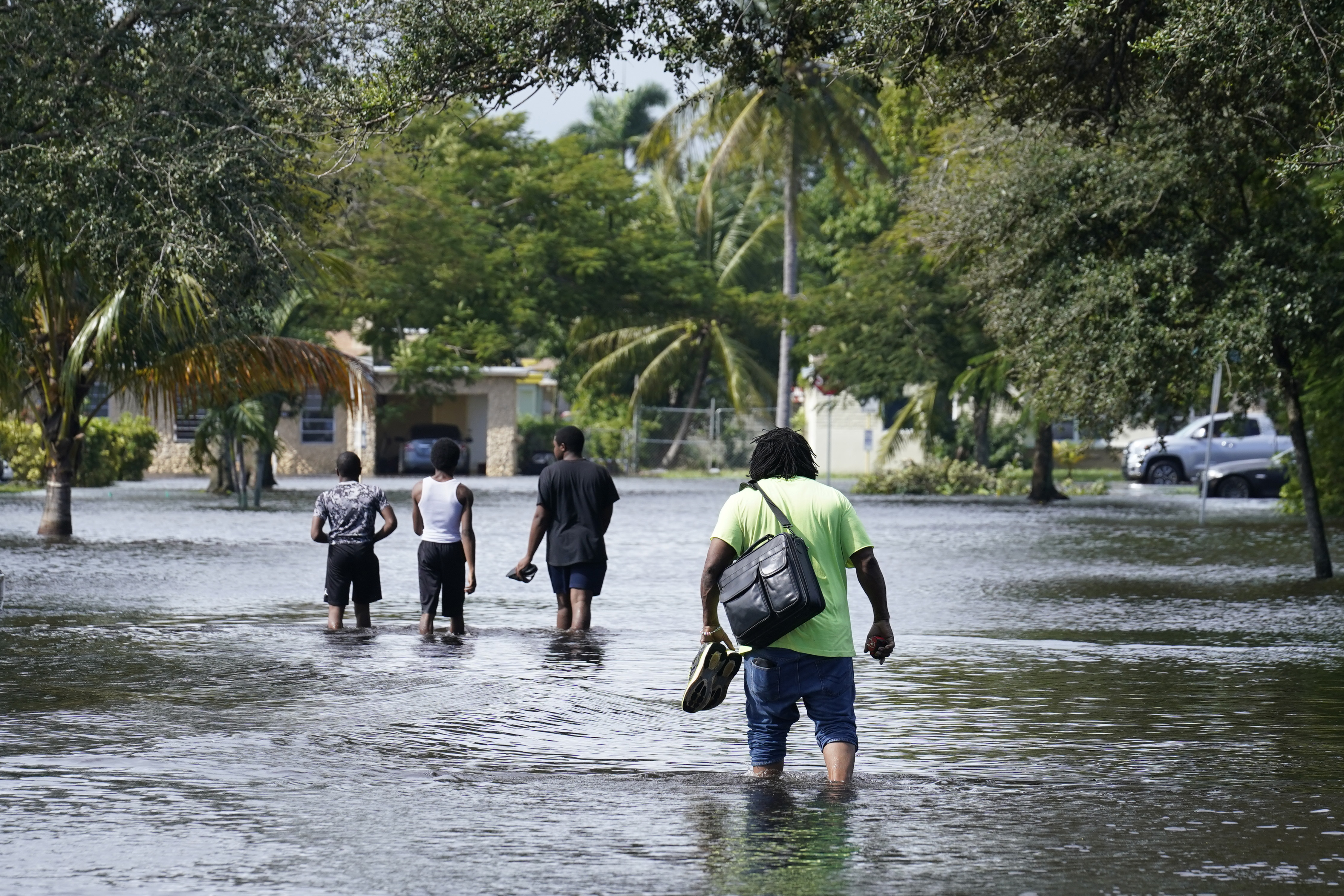 Residents walking through a flooded street to reach their homes in Fort Lauderdale, Florida