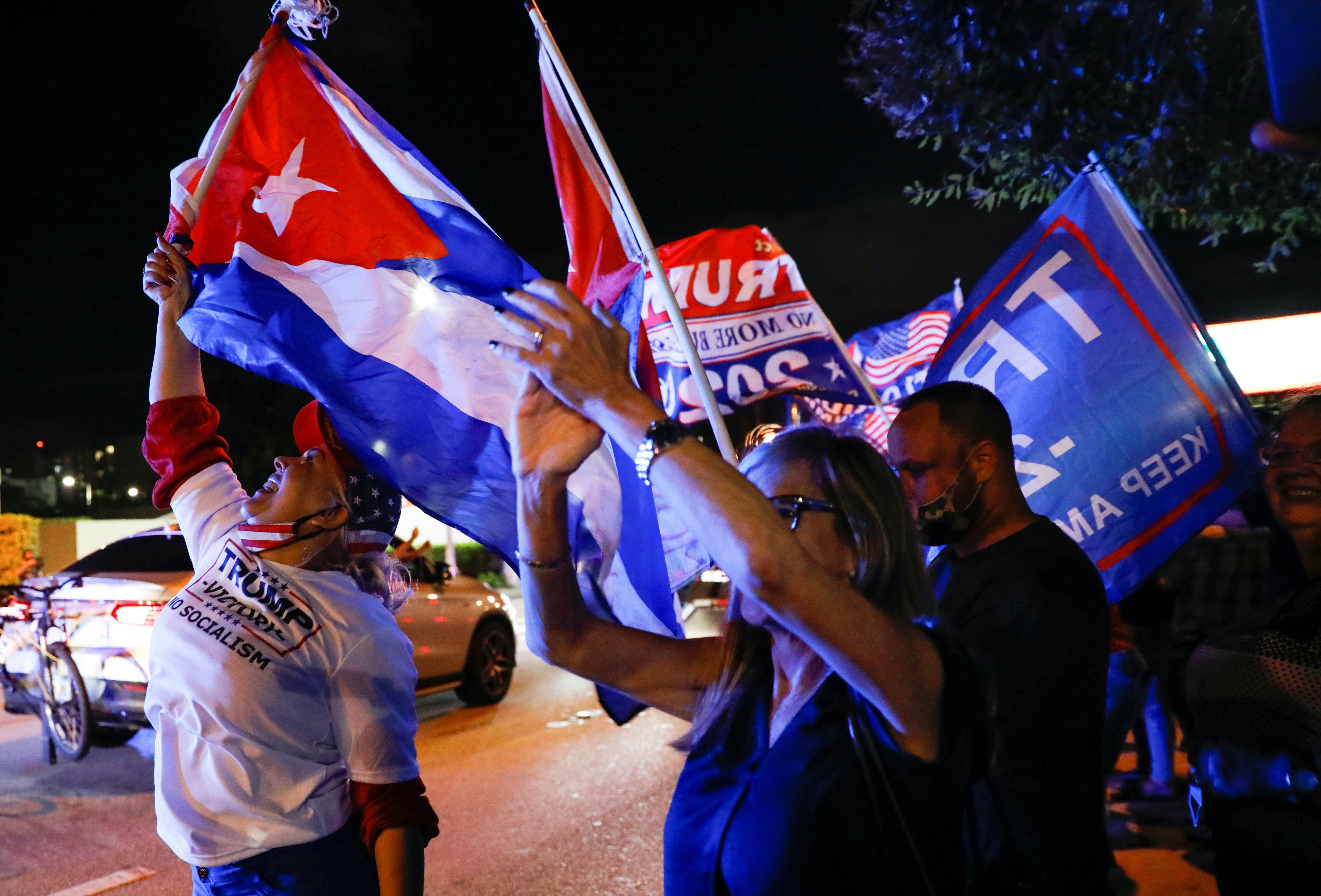 A supporter of US President Donald Trump holds a Cuban flag during the 2020 US presidential election, in Miami, Florida, the United States