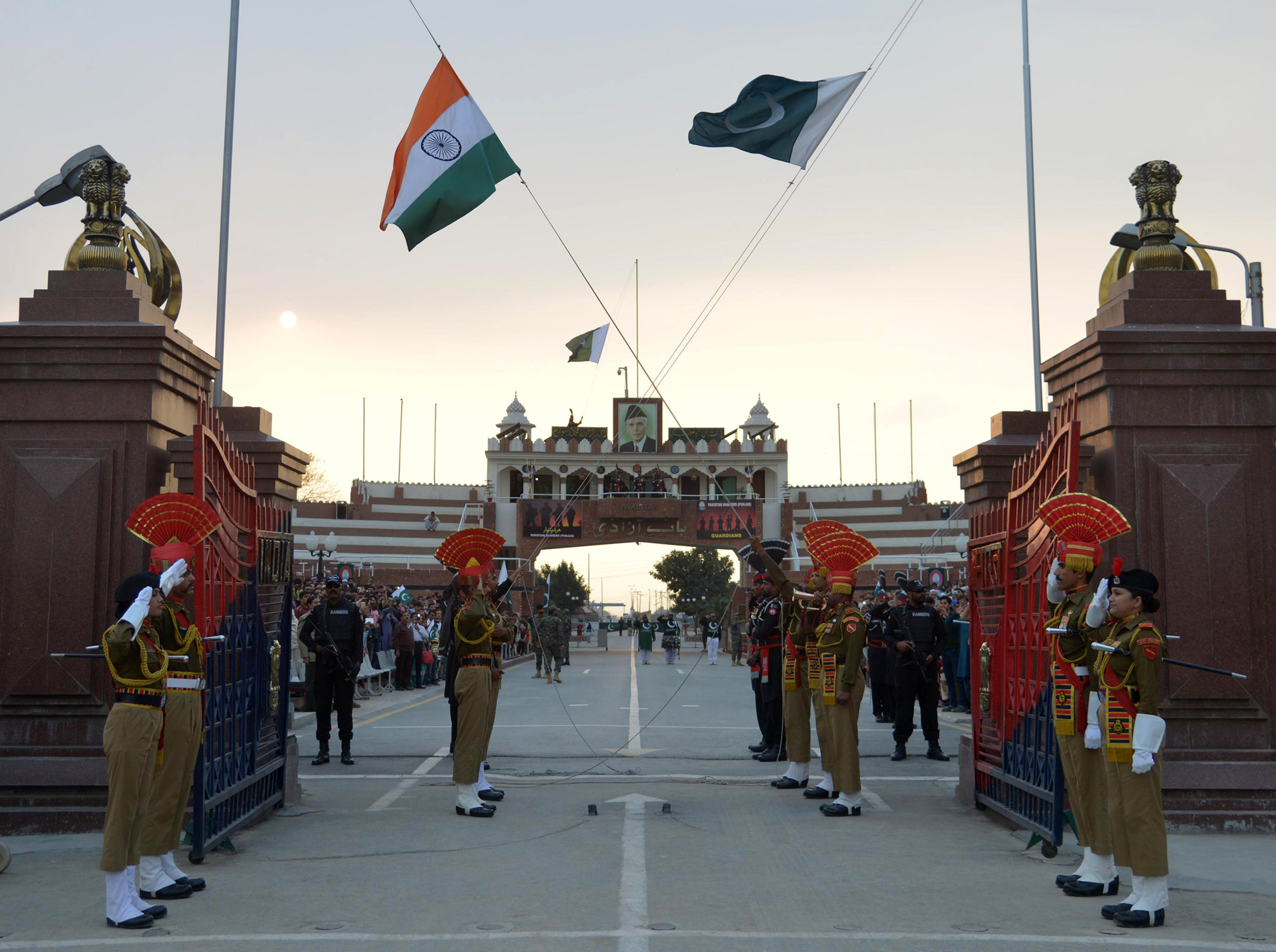 Pakistani Rangers and Indian Border Security Force (BSF) personnel salute their national flags as they perform during the daily beating of the retreat ceremony on the India-Pakistan Border at Wagah on February 20, 2017 [File: AFP/Narinder Nanu]