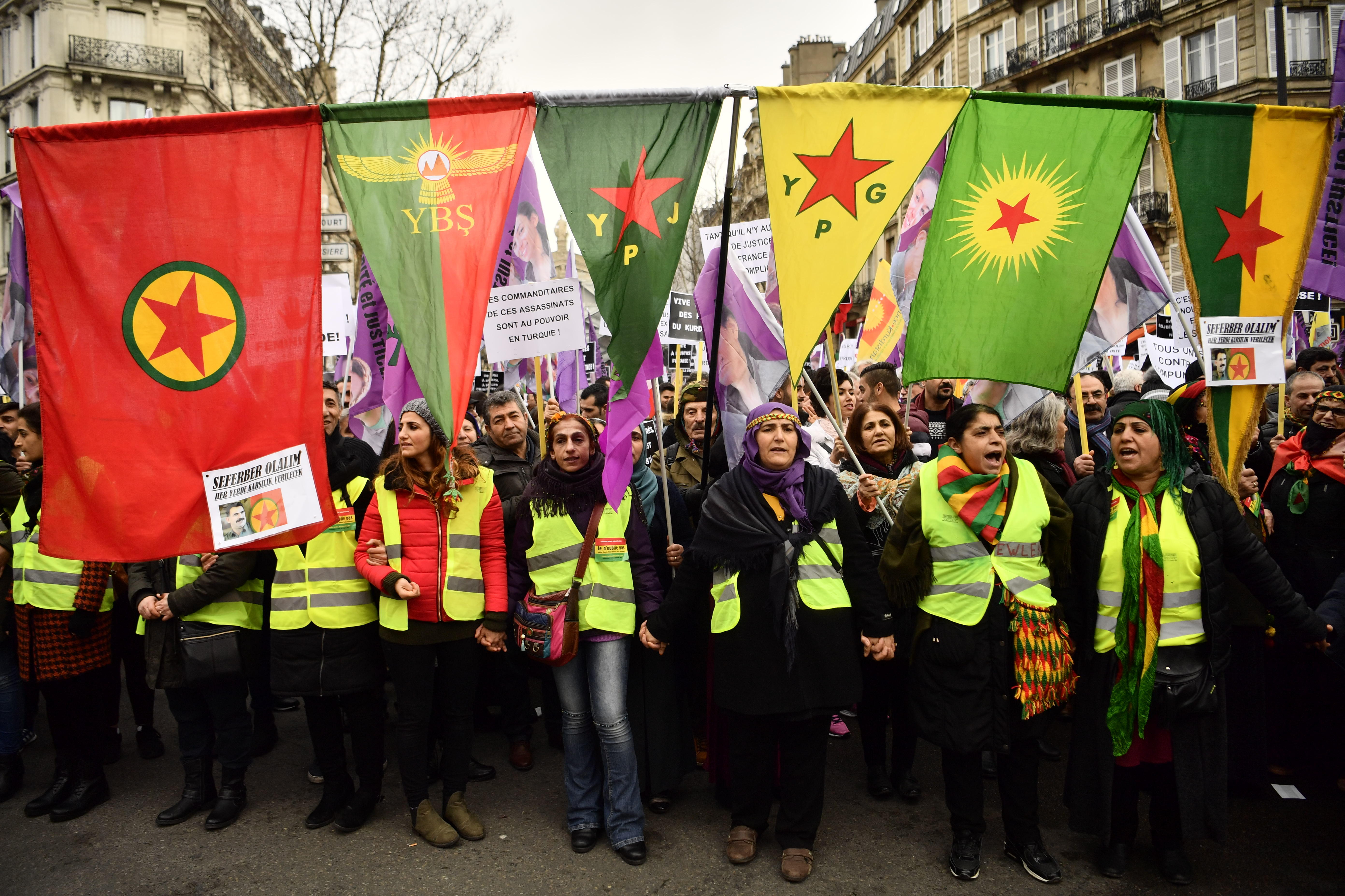 People hold flags of the Kurdistan Workers' Party (PKK) and armed forces.