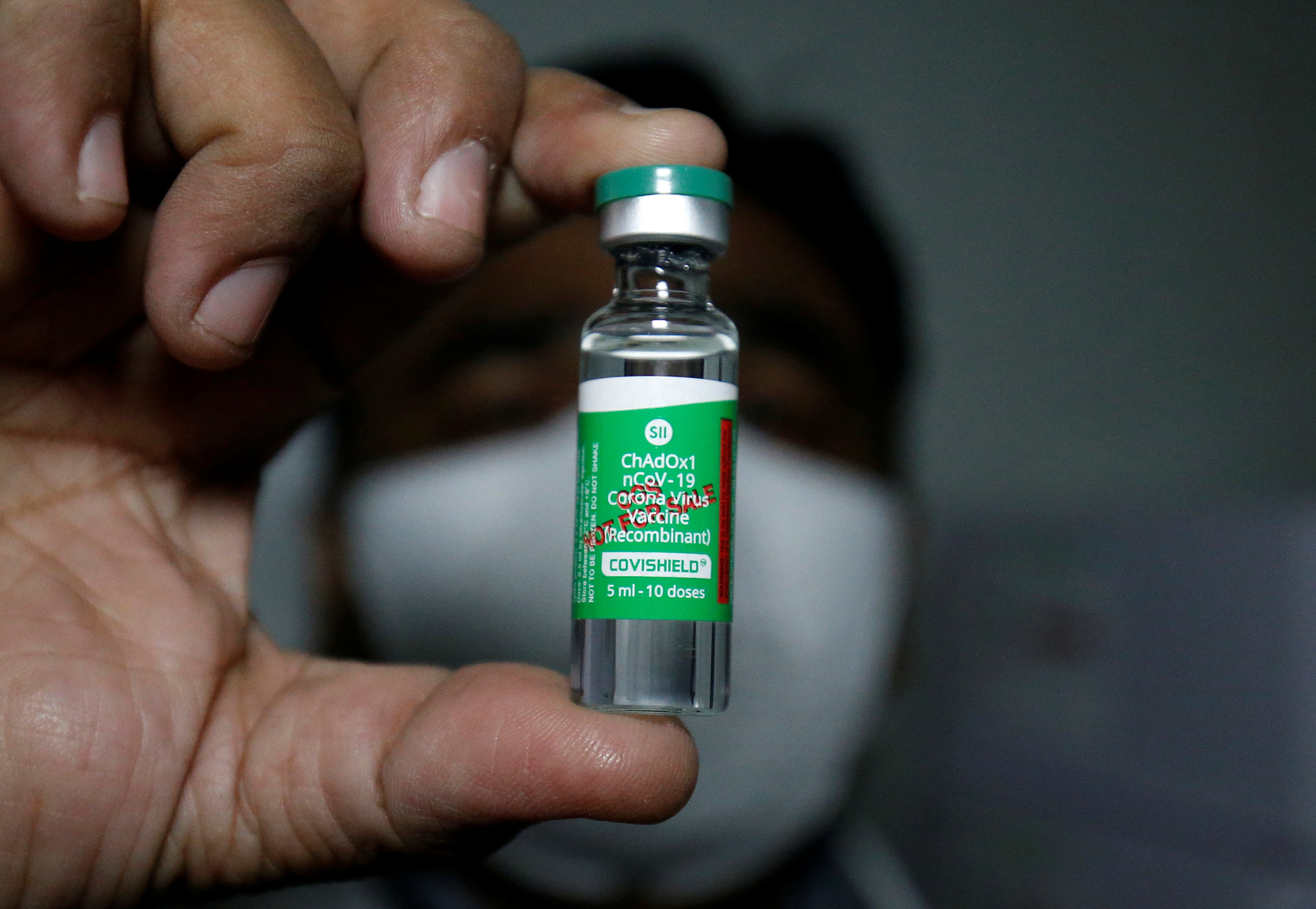 An official displays a vial containing the Covishield vaccine inside a vaccination storage centre in Ahmedabad, India