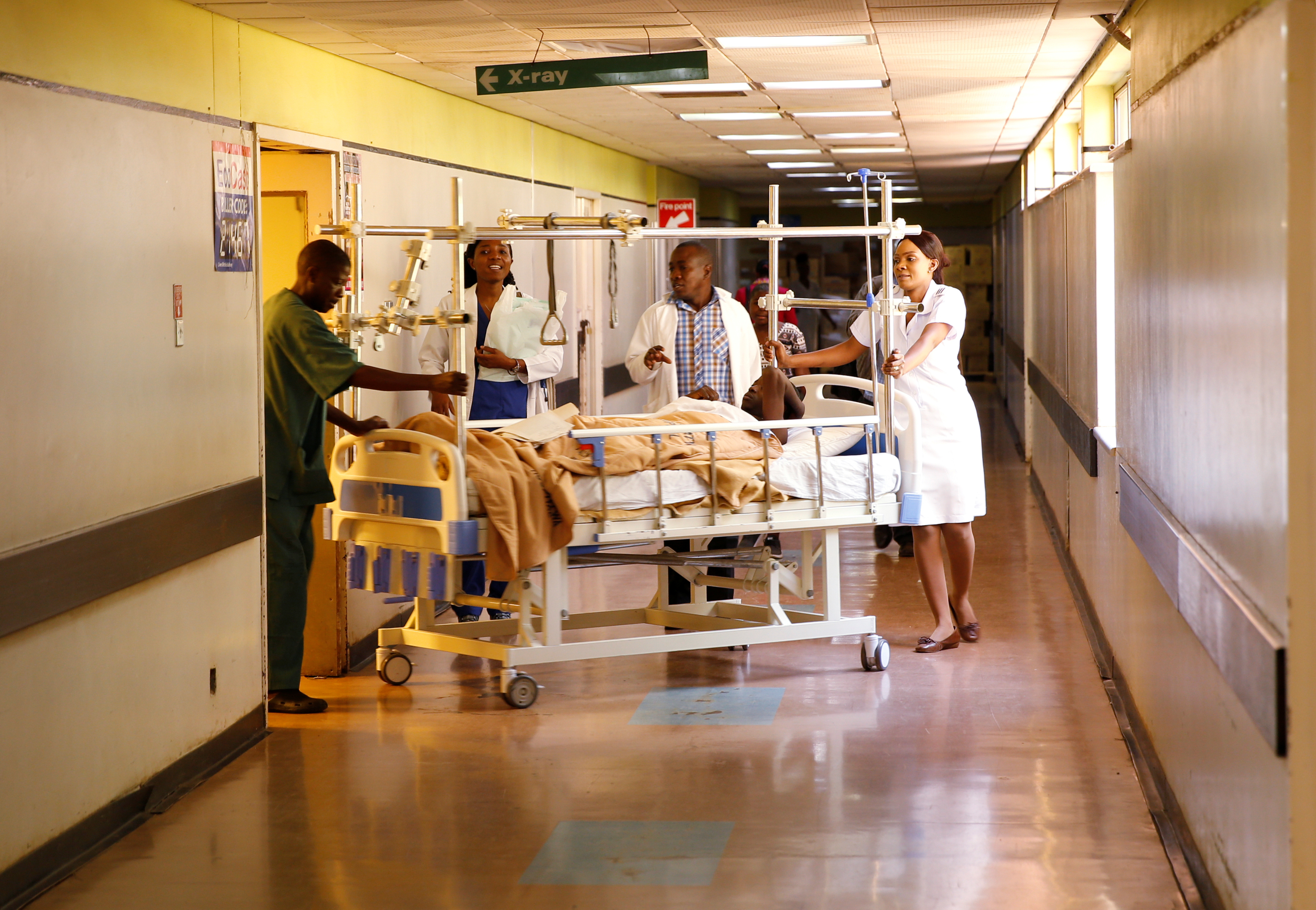 Medical staff are seen assisting a patient at a hospital in Harare, Zimbabwe