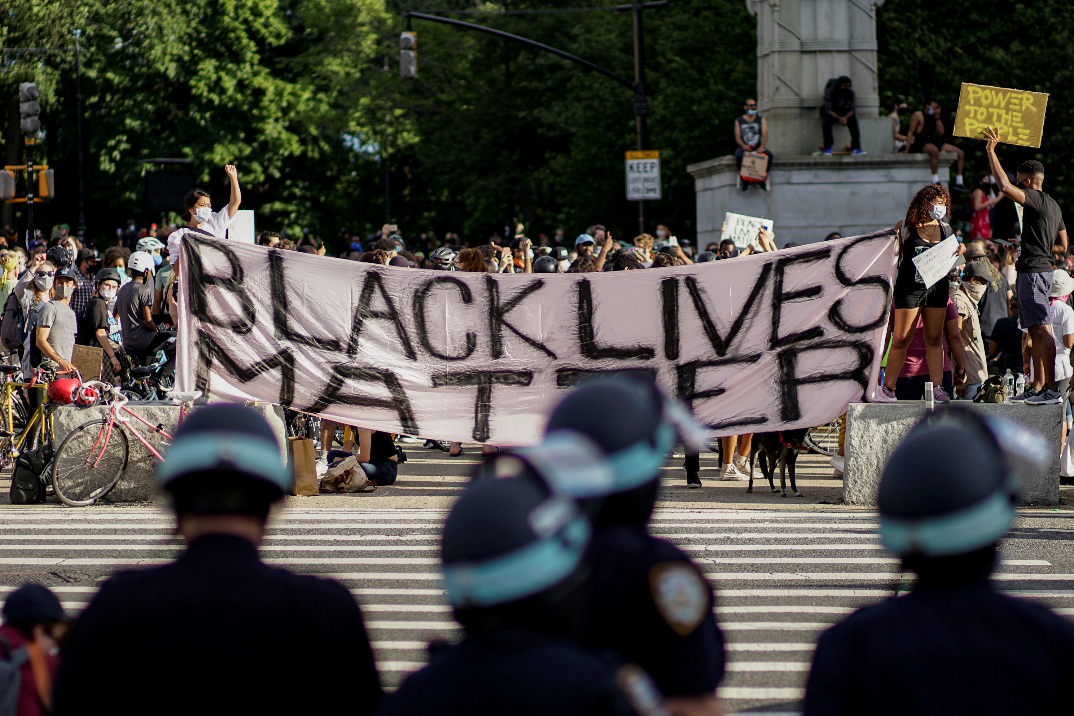 Demonstrators hold a Black Lives Matter banner during a protest against racial inequality after the killing of George Floyd by a Minneapolis police officer, in front of the Grand Army Plaza in Brooklyn, New York in June 2020 [Eduardo Munoz/Reuters]