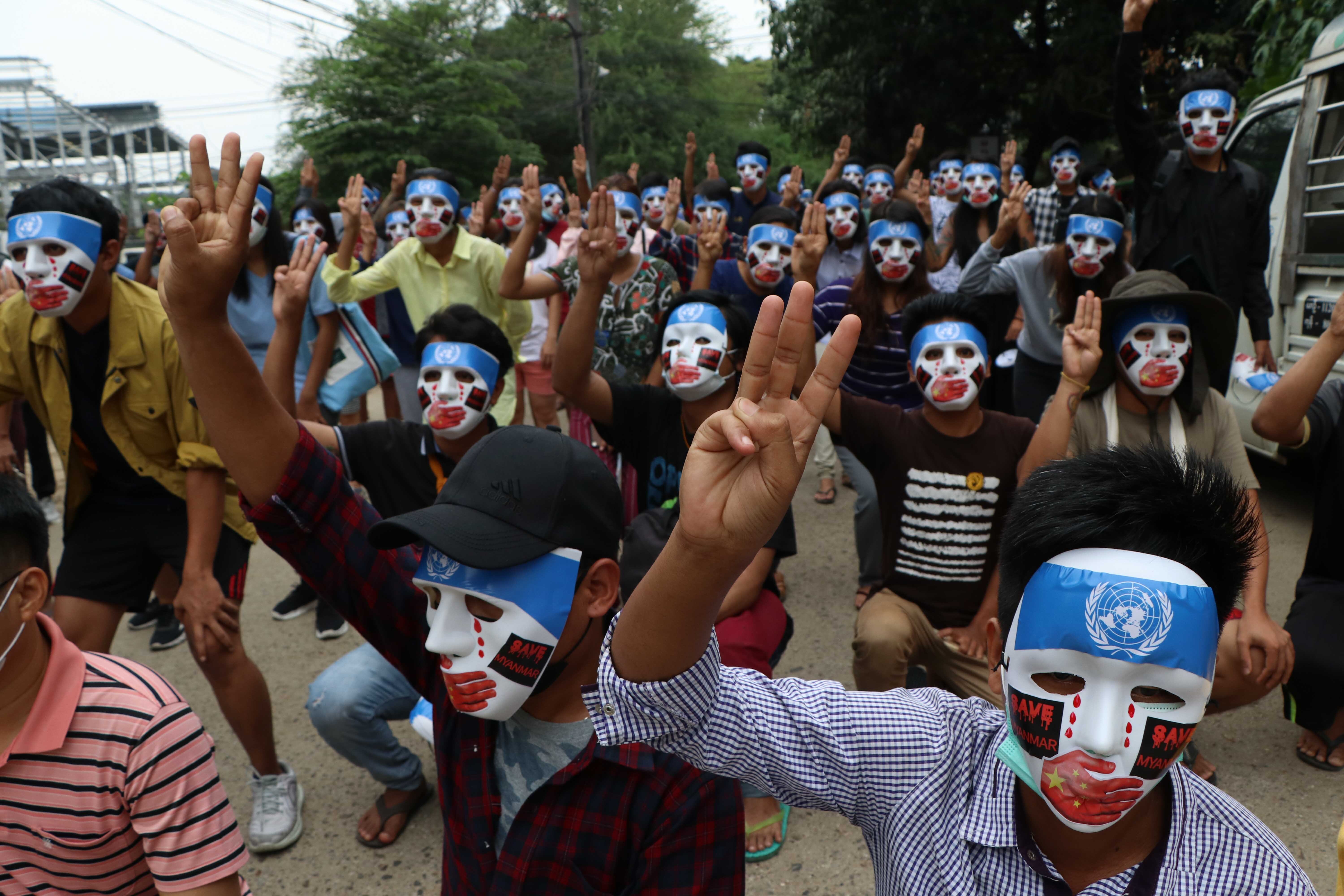 Protesters wear masks showing the UN flag on their foreheads and a Chinese flag covering their mouths during a demonstration against the military coup in Yangon, Myanmar on April 4, 2021, to depict China blocking a United Nations Security Council statement condemning the military coup in Myanmar