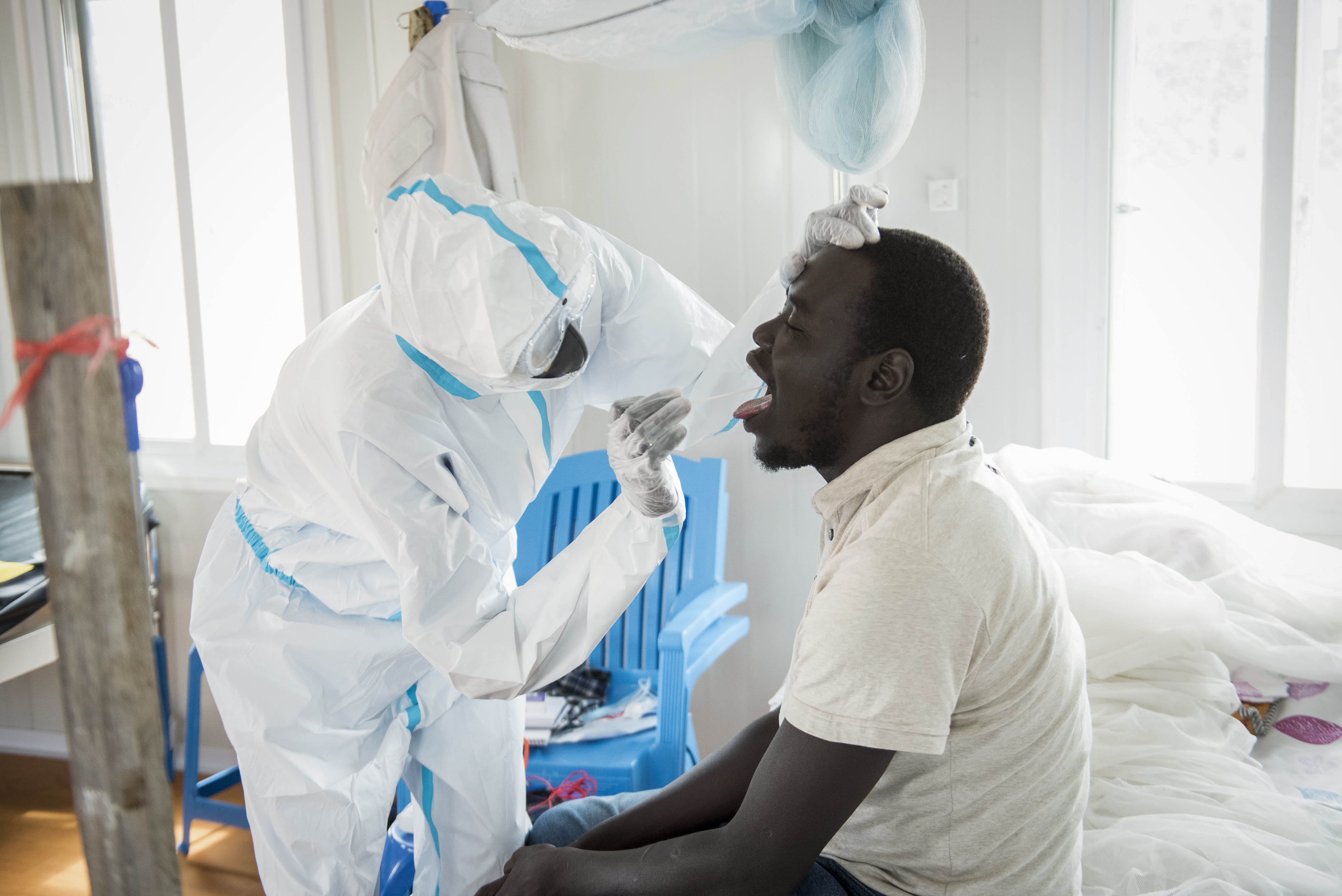 An infectious disease specialist takes a sample from Dr Reagan Taban Augustino, now a coronavirus patient himself under quarantine, at the Dr John Garang Infectious Diseases Unit in Juba, South Sudan on June 21, 2020 [File: AP/Charles Atiki Lomodong]