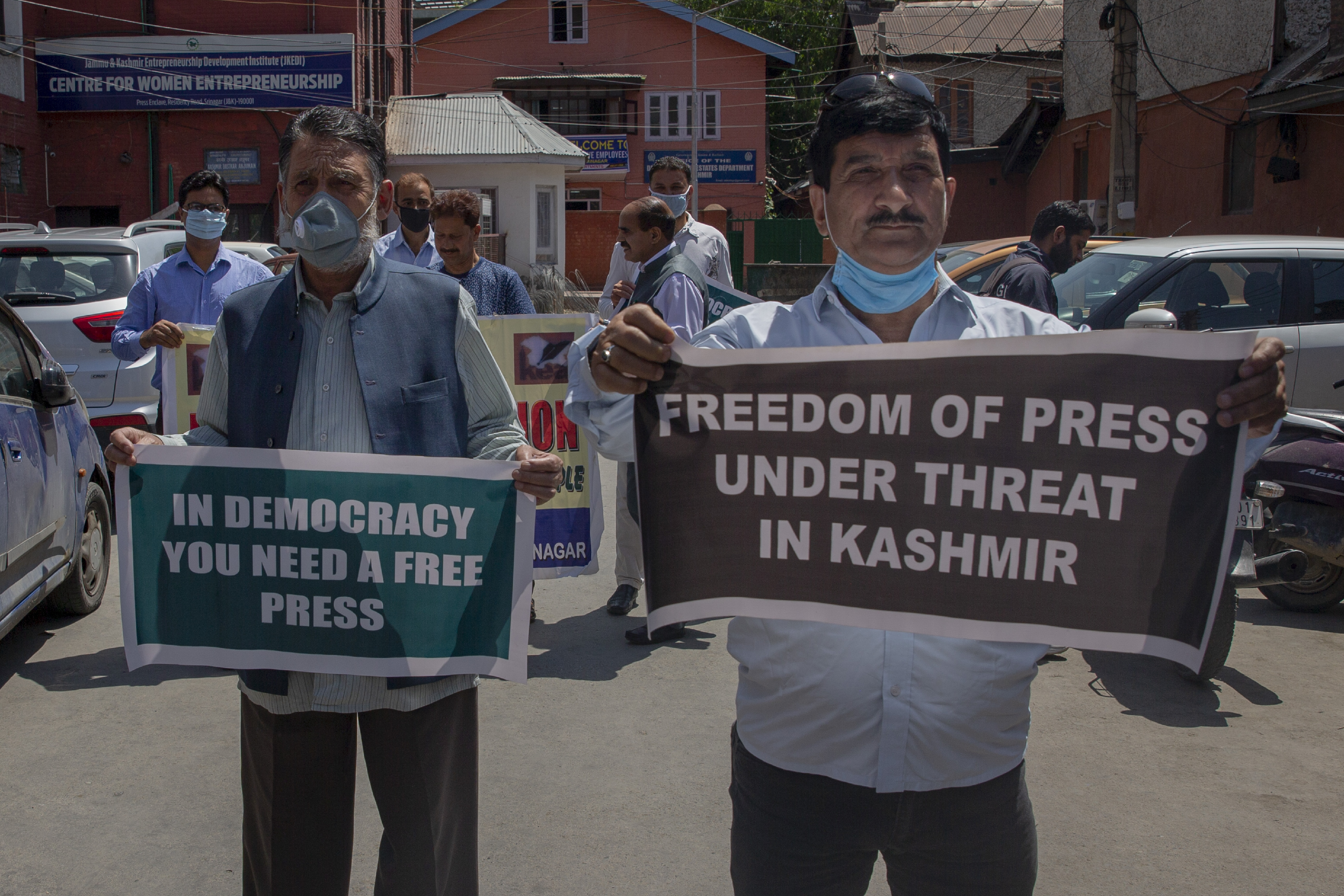 Men with posters stand in a street
