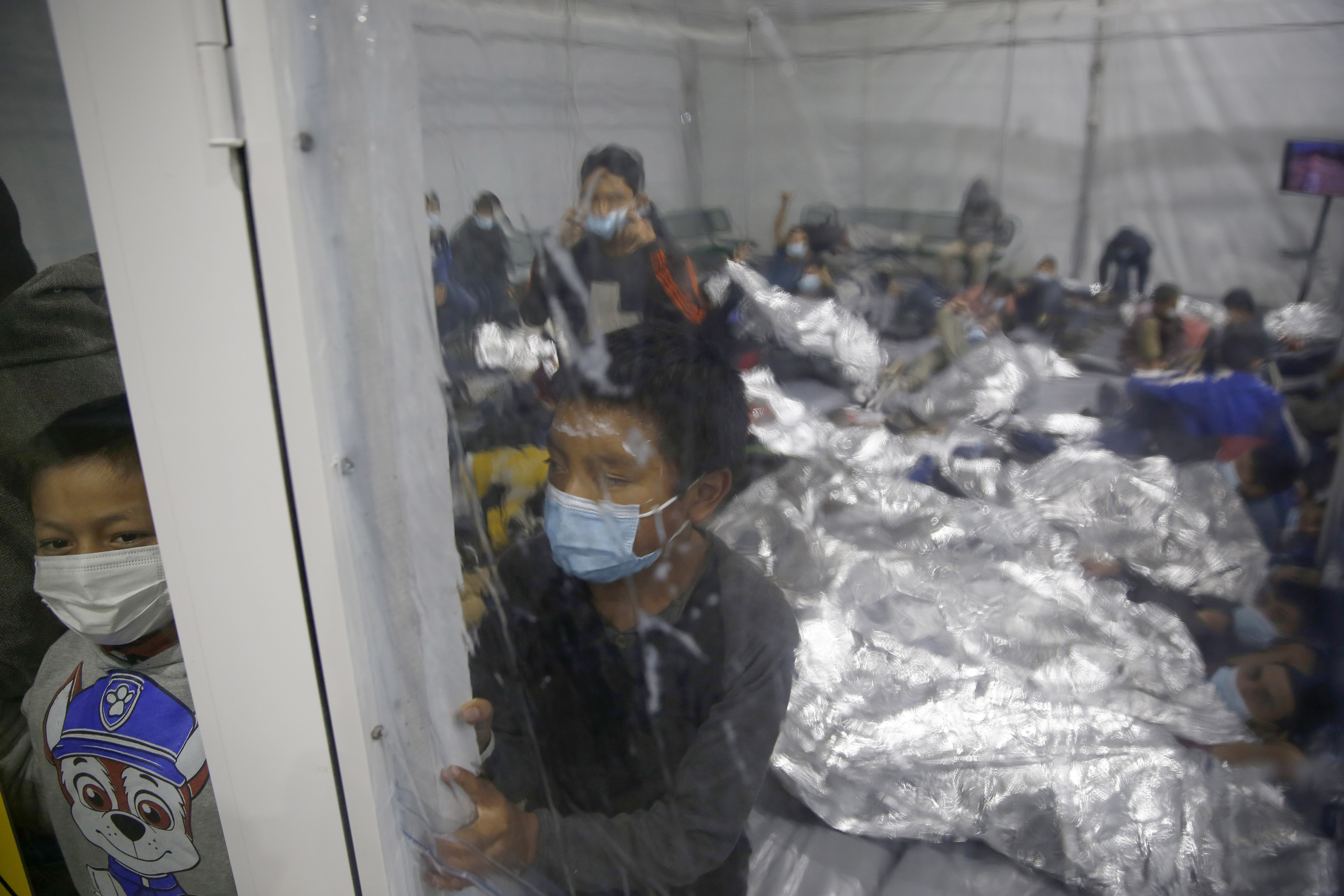 Young children look outside from a pod at the Donna Department of Homeland Security holding facility, the main detention centre for unaccompanied children in the Rio Grande Valley run by the Customs and Border Protection, in Donna, Texas, March 30, 2021 [Dario Lopez-Mills/AP Photo]