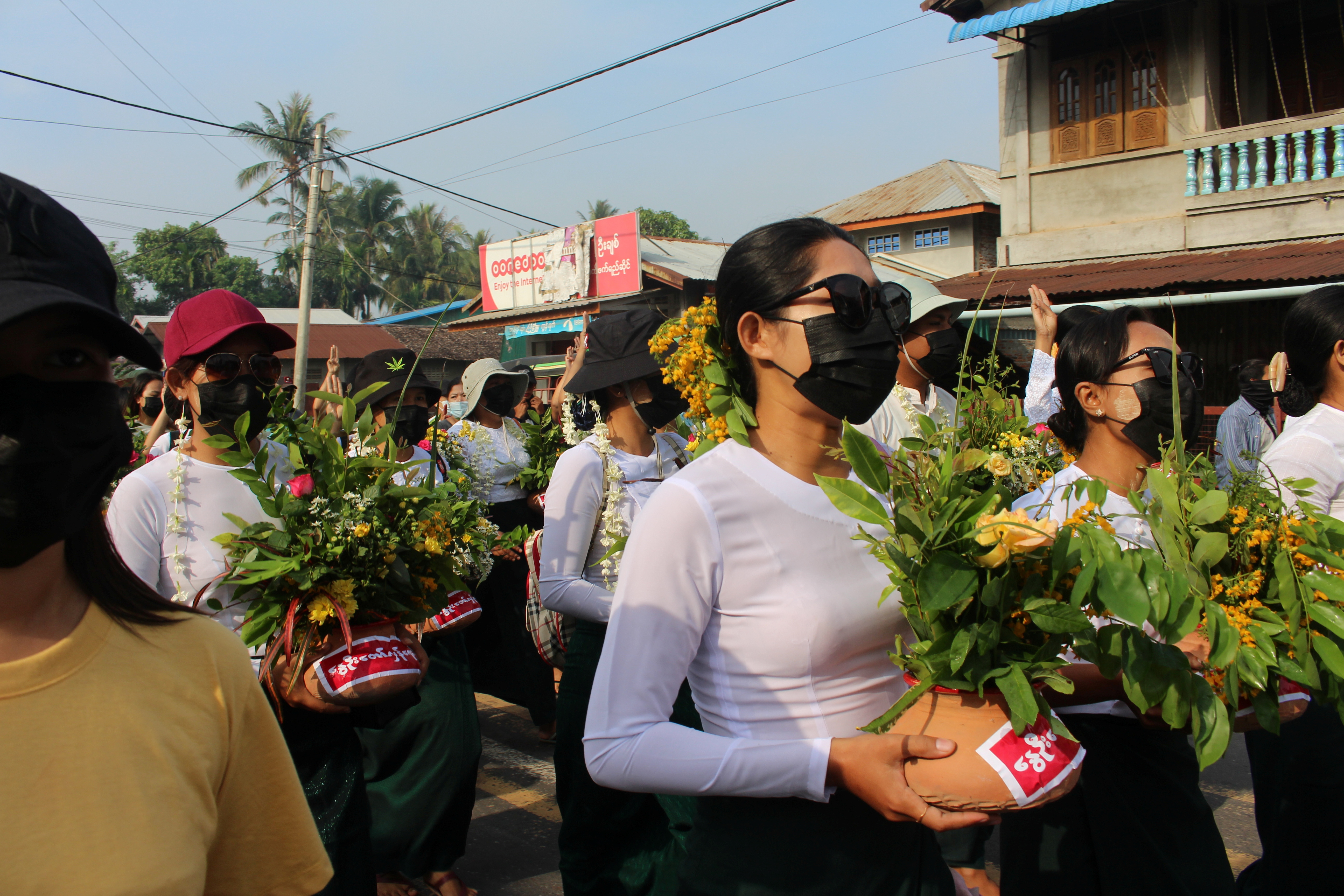 People march holding Thingyan pots with padauk flowers – flowers that are used to welcome the Burmese New Year which falls in April – as they protest against the military coup in Dawei, Myanmar on April 13, 2021