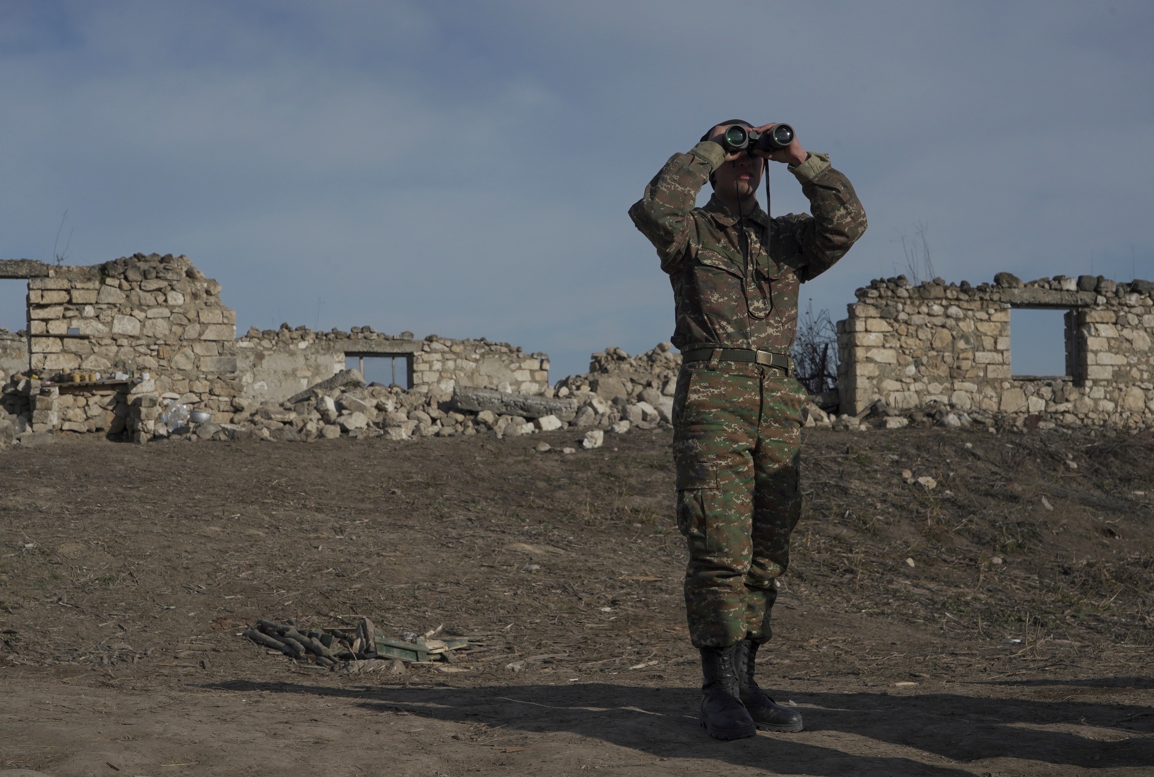 FILE PHOTO: An ethnic Armenian soldier looks through binoculars as he stands at fighting positions near the village of Taghavard in the region of Nagorno-Karabakh, January 11, 2021. Picture taken January 11, 2021. REUTERS/Artem Mikryukov/File Photo
