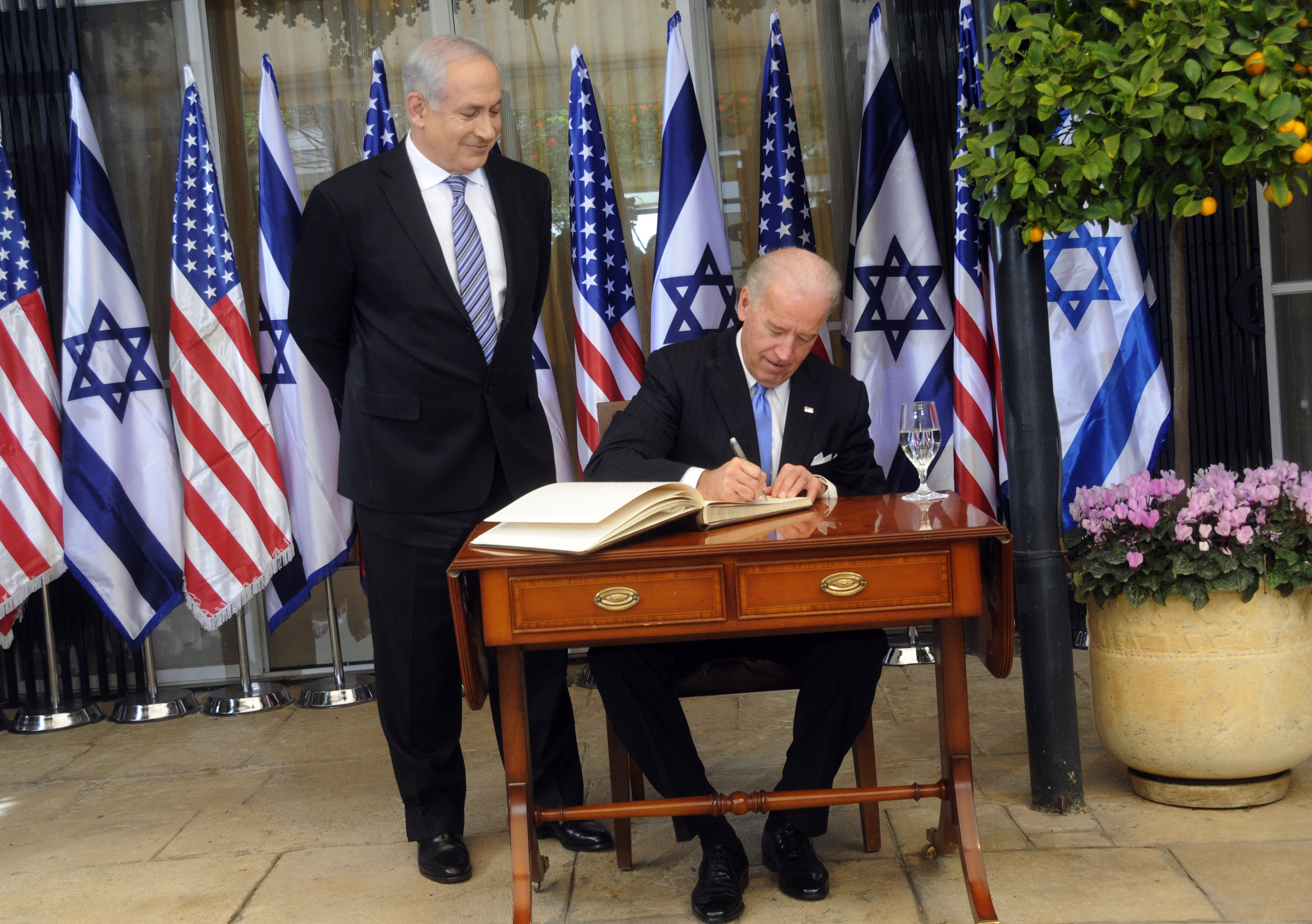 Benjamin Netanyahu, left, looks on as then-US Vice President Joe Biden signs the guest book at the then-prime minister's residence in Jerusalem, March 9, 2010
