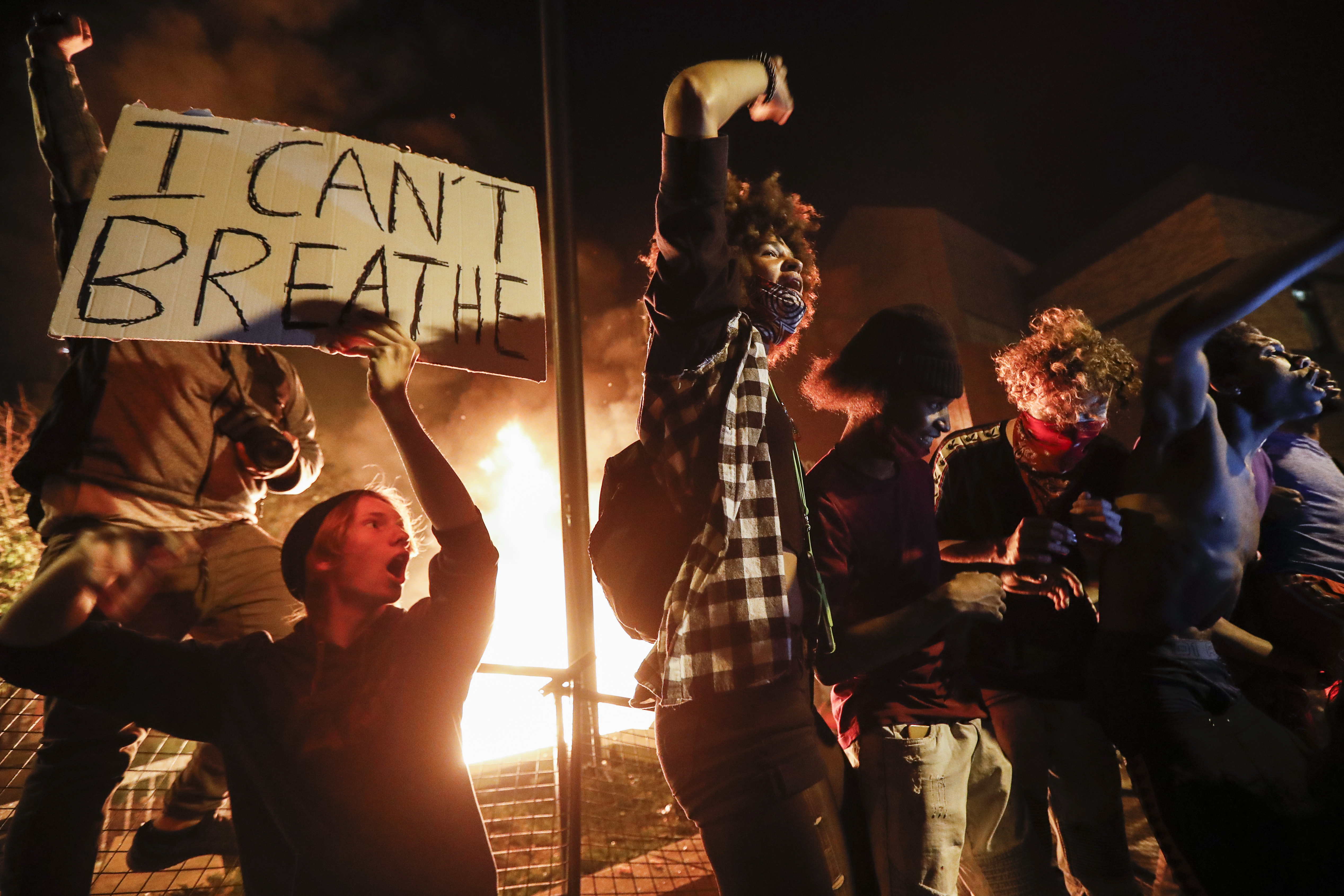 Protesters demonstrate outside a burning Minneapolis Third Police Precinct on May 28, 2020, in Minneapolis [File: John Minchillo/AP Photo]