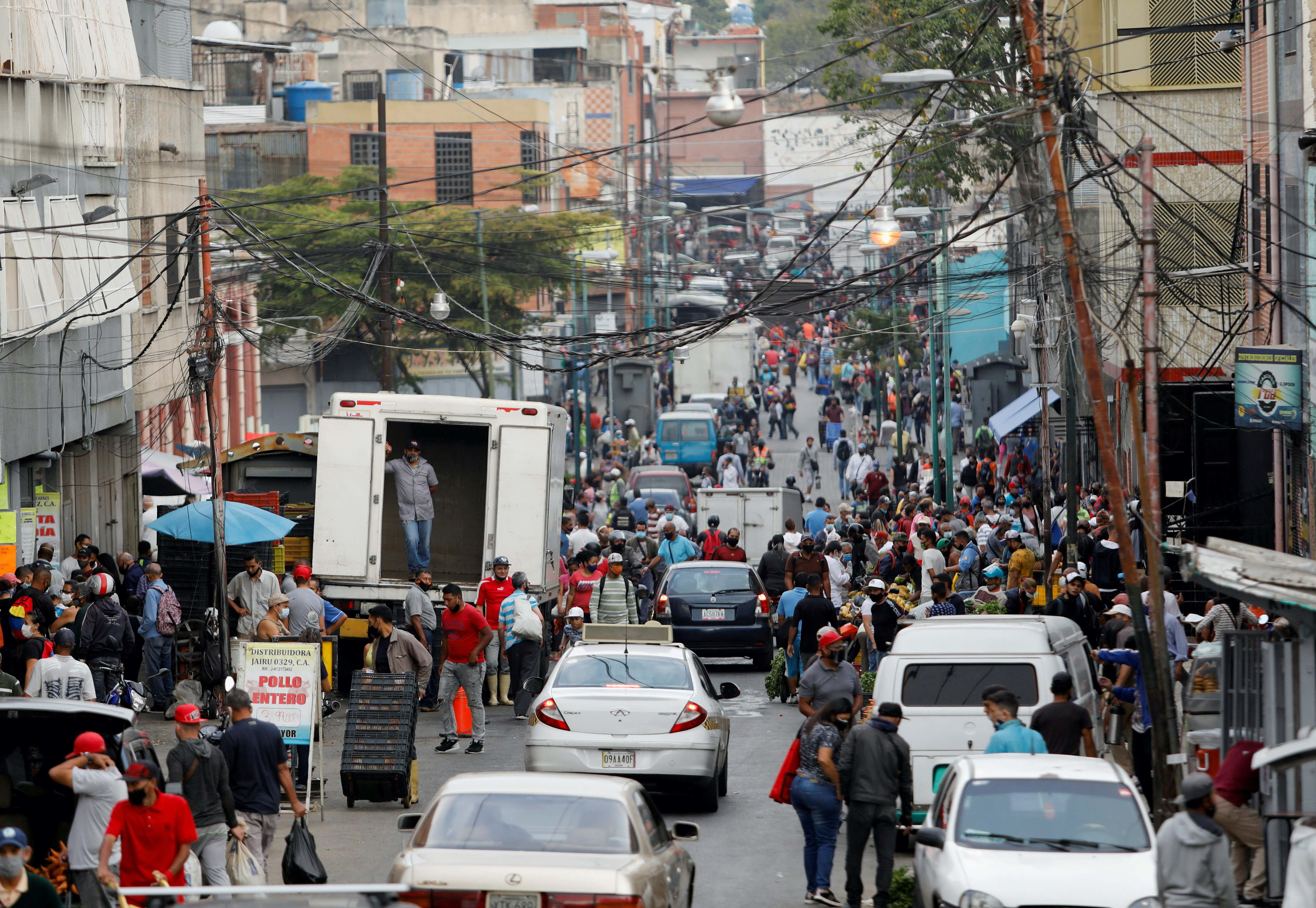 People walk on a busy commercial street amid a spike in infections of the coronavirus disease that has led the government to extend lockdown measures, in Caracas, Venezuela