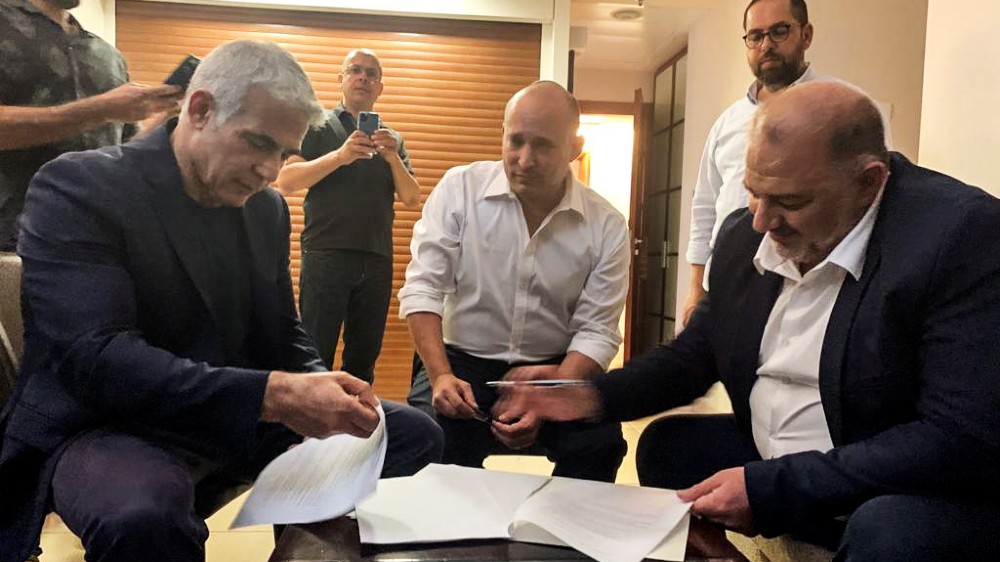 United Arab List party leader Mansour Abbas, right, joined hands with Yamina party leader Naftali Bennett and Yesh Atid party leader Yair Lapid near Tel Aviv, Israel
