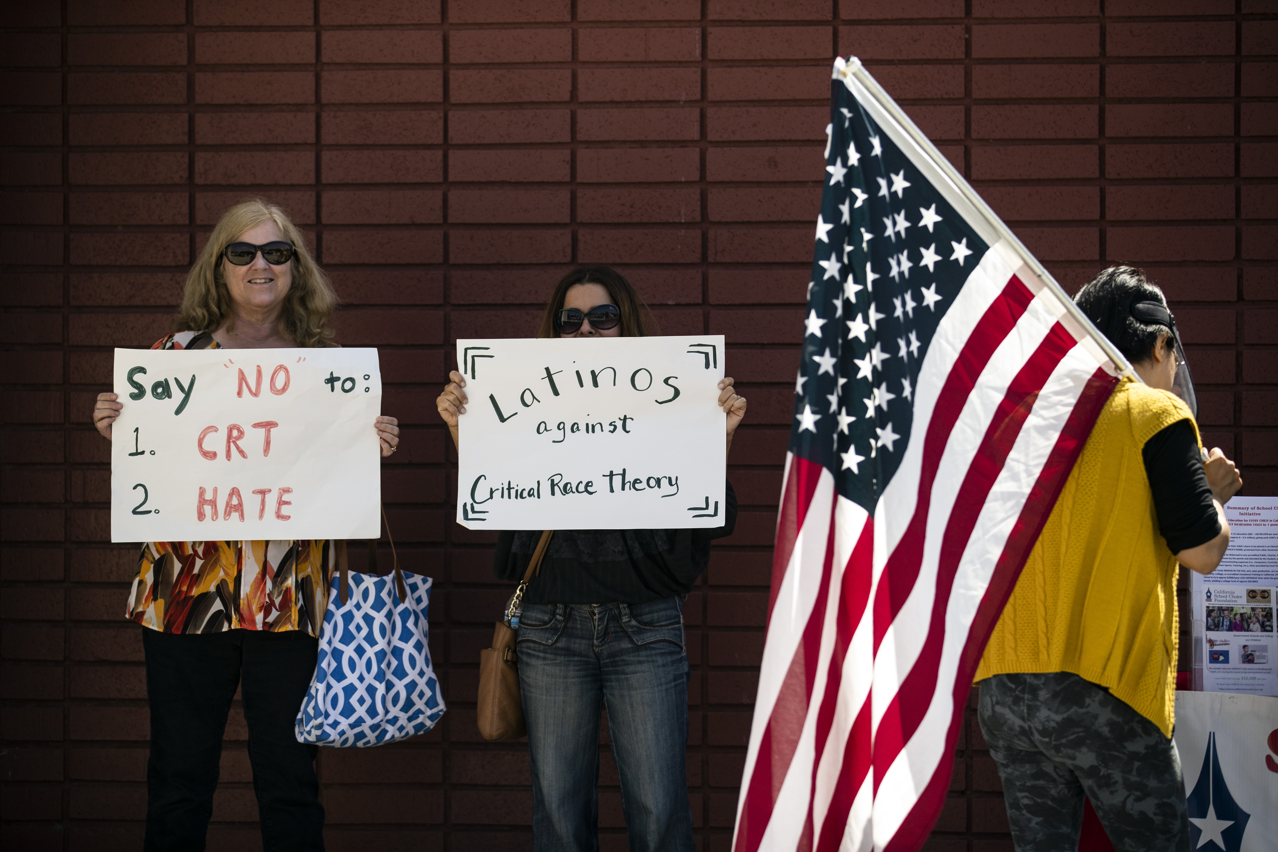Protesters hold posters opposing "critical race theory" during a demonstration in front of the Los Alamitos Unified School District building, Los Alamitos, California, May 11, 2021 [Etienne Laurent/EPA-EFE]