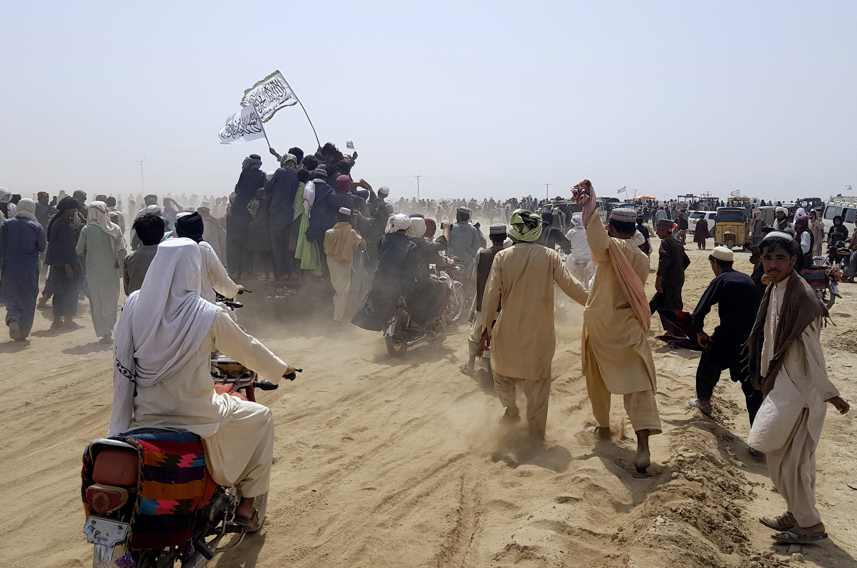 Taliban supporters carry its flag at the Afghanistan-Pakistan border town of Chaman, Pakistan