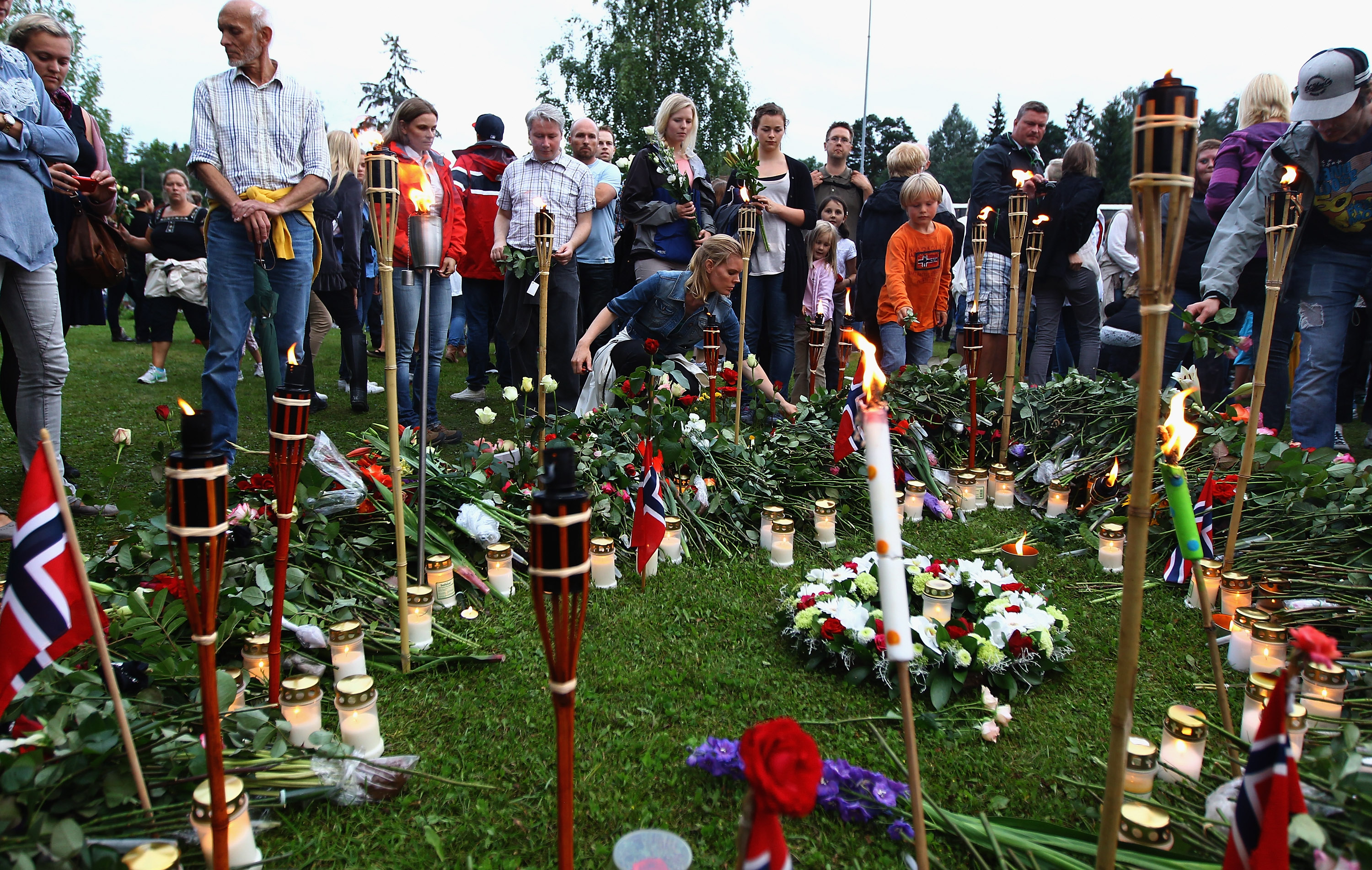 People lay flowers following a vigil walk near Utoya Island on July 26, 2011 in Sundvolden, Norway. [Jeff J Mitchell/Getty Images]
