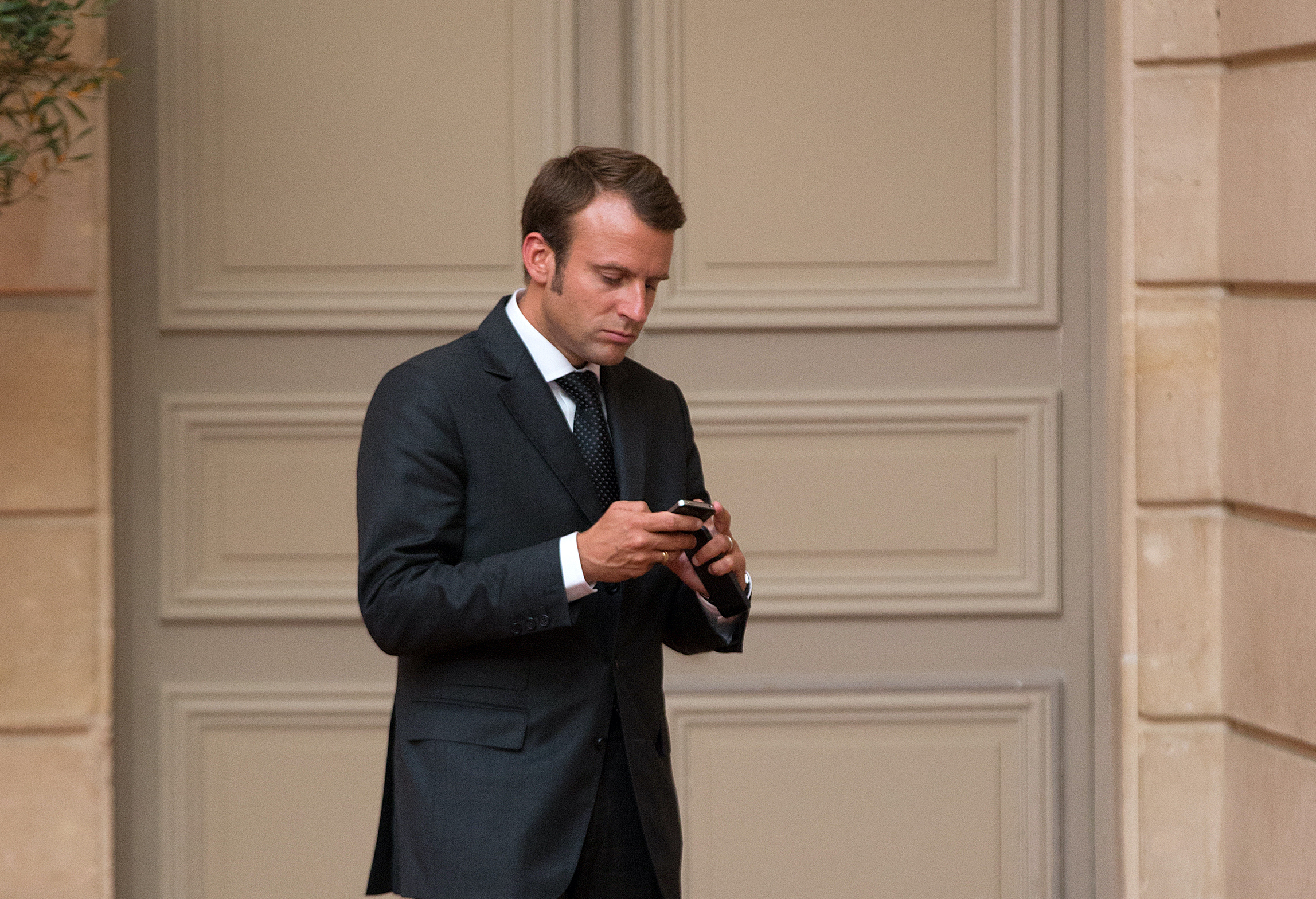 French Economy Minister Emmanuel Macron uses his mobile phone as he arrives at a dinner attended by French President Francois Hollande and Saudi Arabia's Prince Salman Bin Abdulaziz Al Saud at the Elysee Palace in Paris, France, 01 September 2014.
