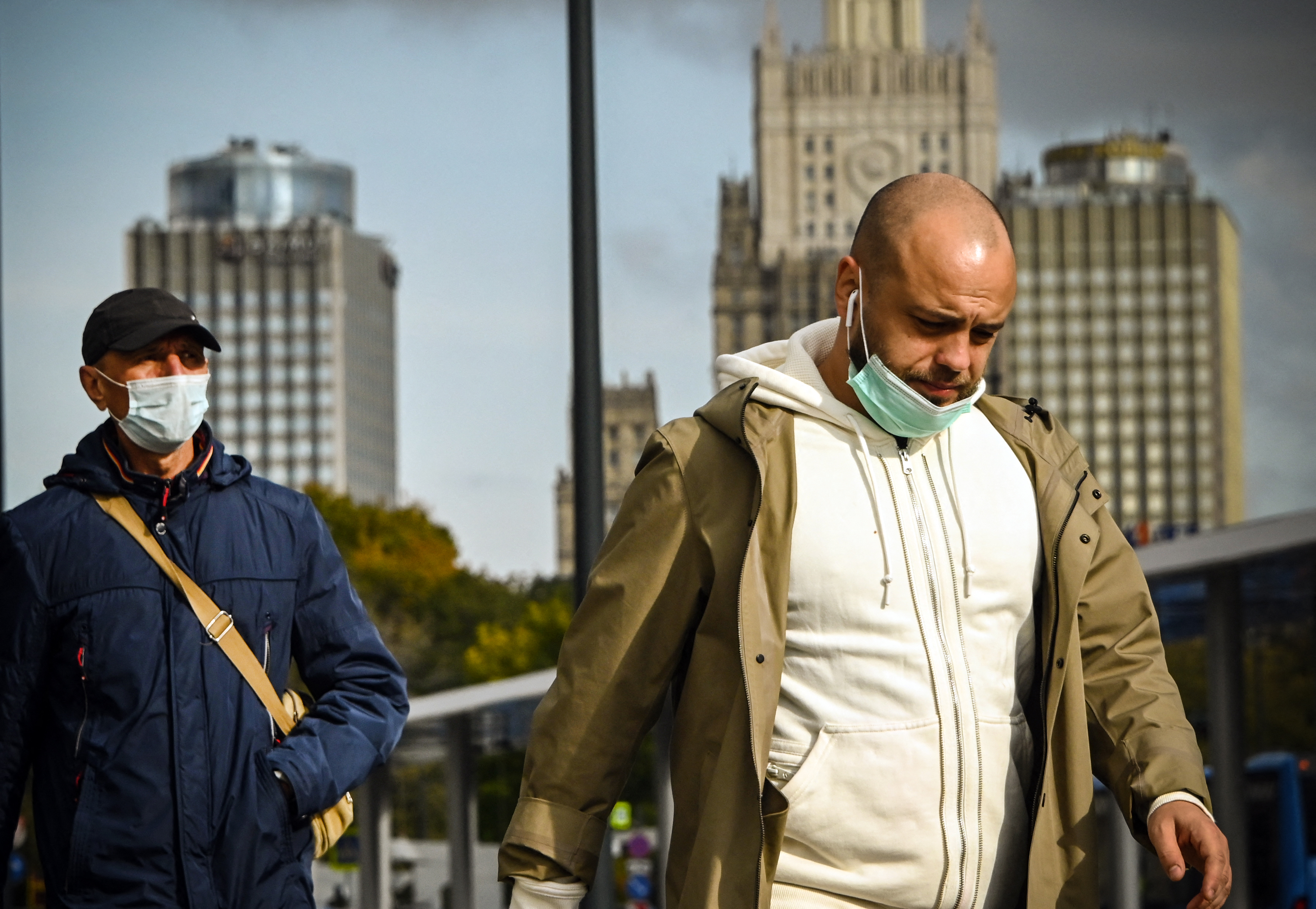 Men wearing face masks walk in central Moscow amid the COVID-19 pandemic caused by the novel coronavirus