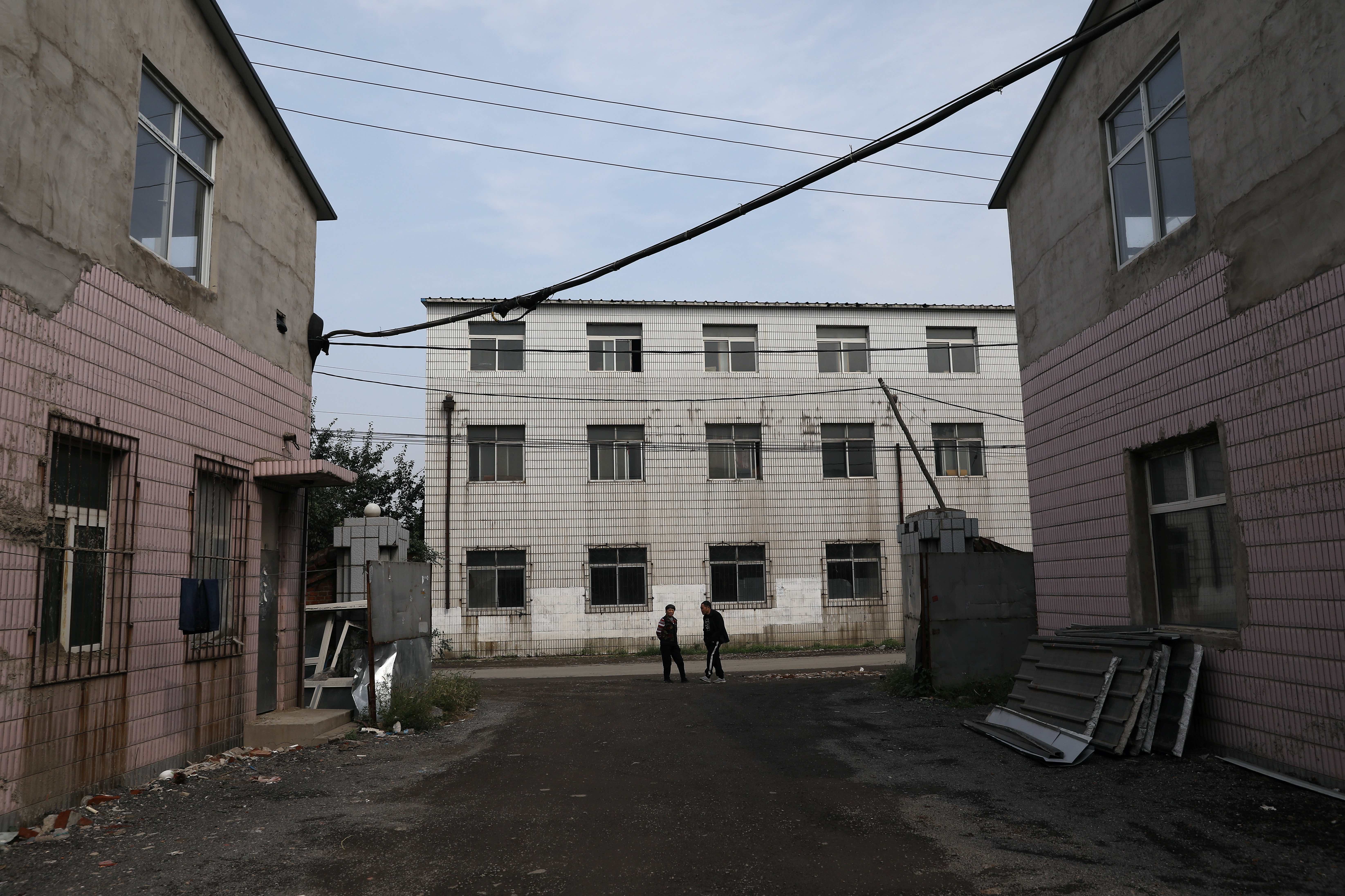 People stand at an industrial park in Shenyang, Liaoning province, China