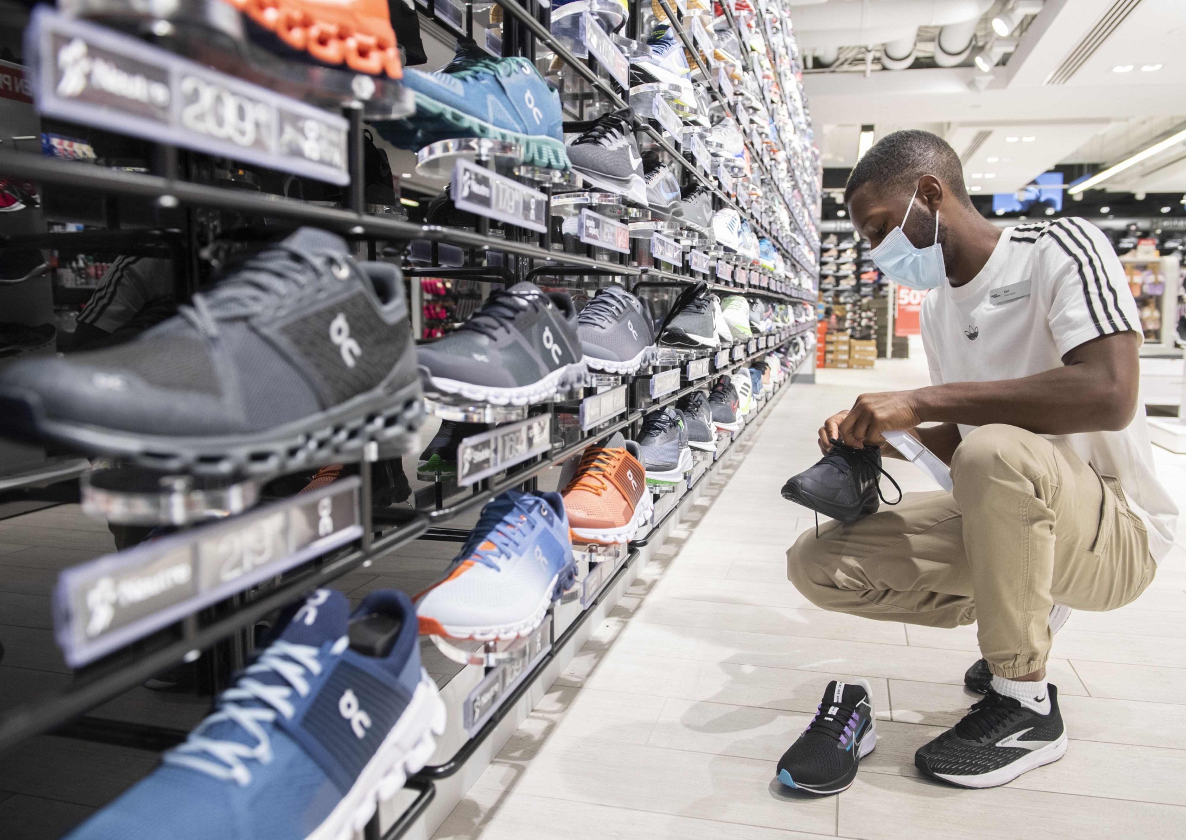 A worker inspects running shoes at a Sports Expertss store on Sainte-Catherine street in Montreal, Quebec, Canada