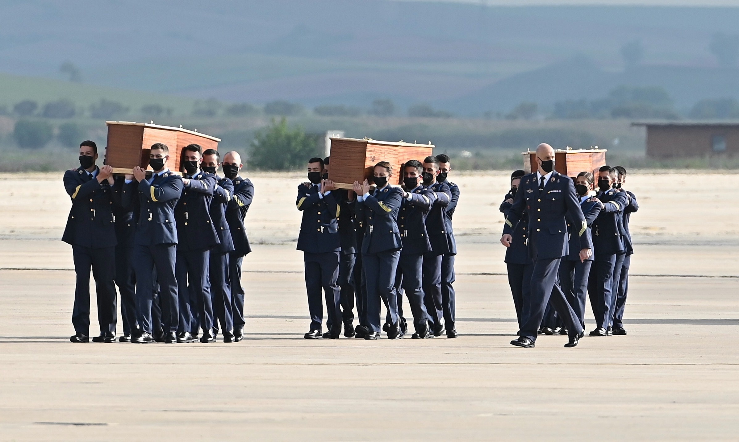 Members of the army carry the coffins of David Beriain, Roberto Fraile and Rory Young, as they arrive at the Torrejon de Ardoz military airport in Madrid, Spain, on April 30, 2021. They were killed in Burkina Faso while working on a documentary about poaching in the Pama area of the country [EPA-EFE/Fernando Villar]
