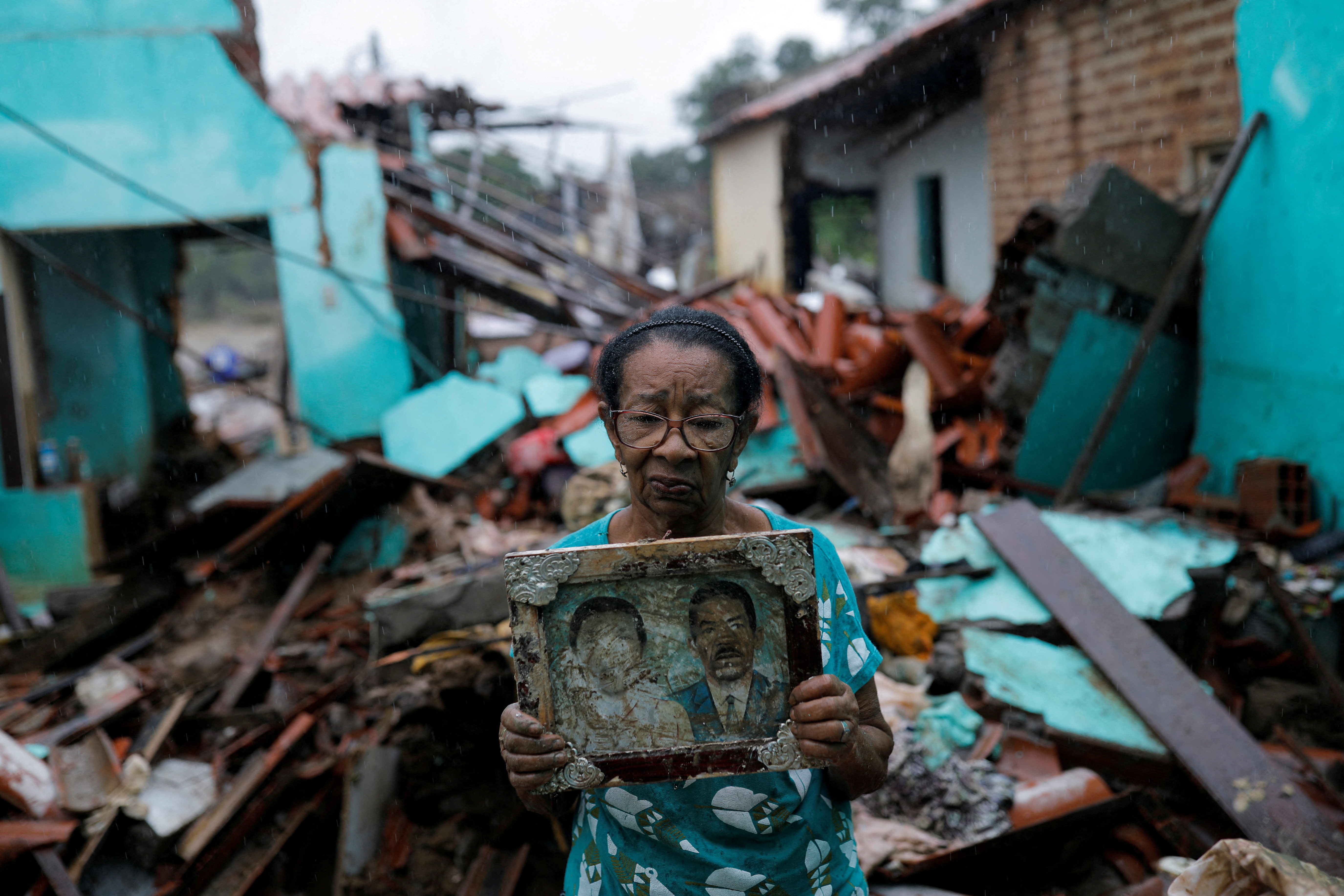 Vitoria Rocha, 81, poses with the picture of her parents