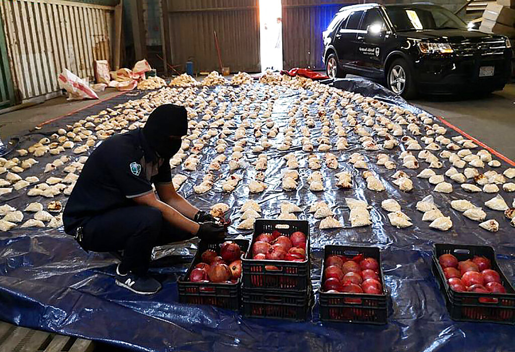 A Saudi custom officer opens imported pomegranates, as customs foiled an attempt to smuggle over 5 million pills of an amphetamine drug known as Captagon from Lebanon