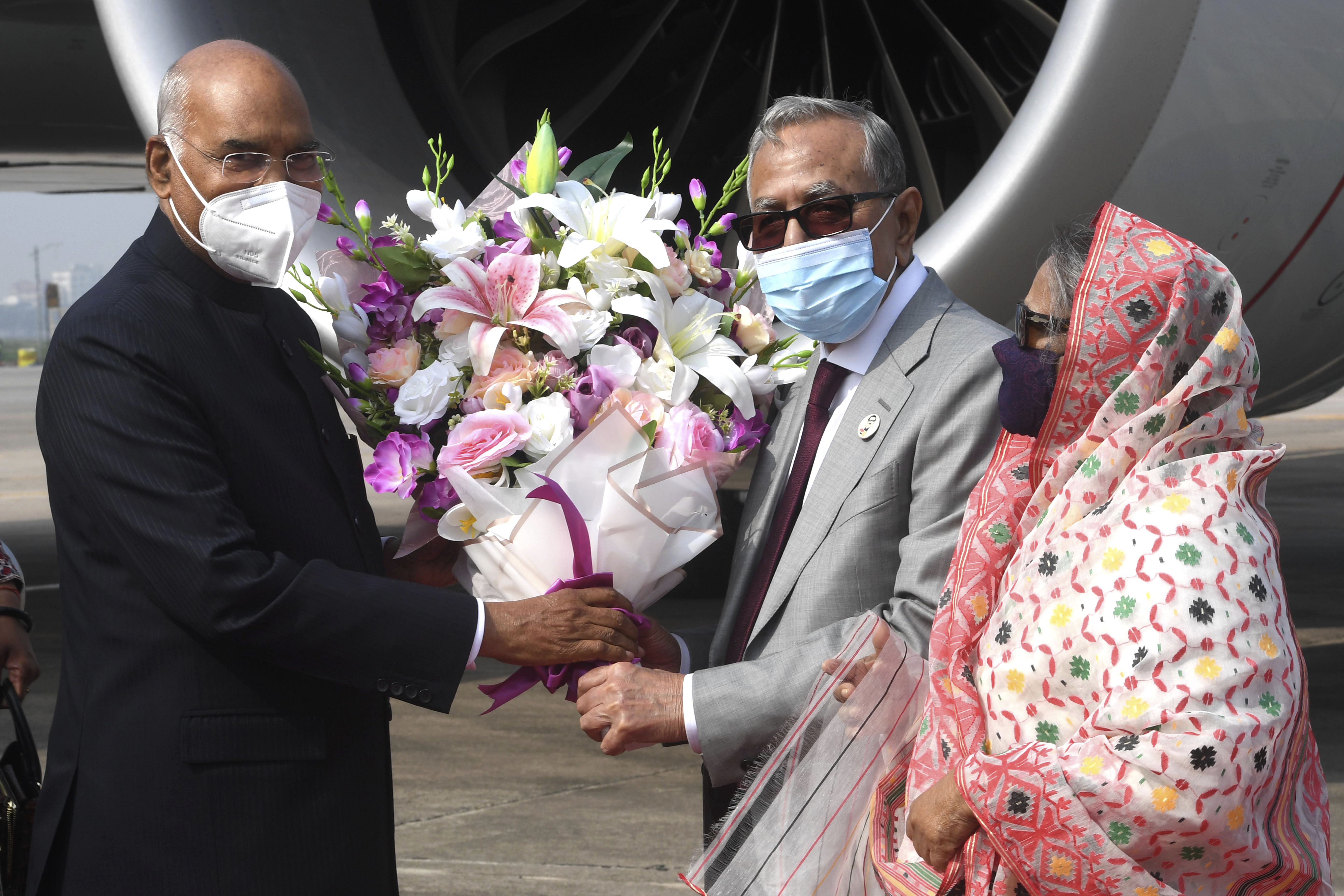 Indian President Ram Nath Kovind, left, is received by Bangladesh President Mohammad Abdul Hamid, centre, at the Hazrat Shahjalal International Airport in Dhaka [Indian Presidential Palace via AP]