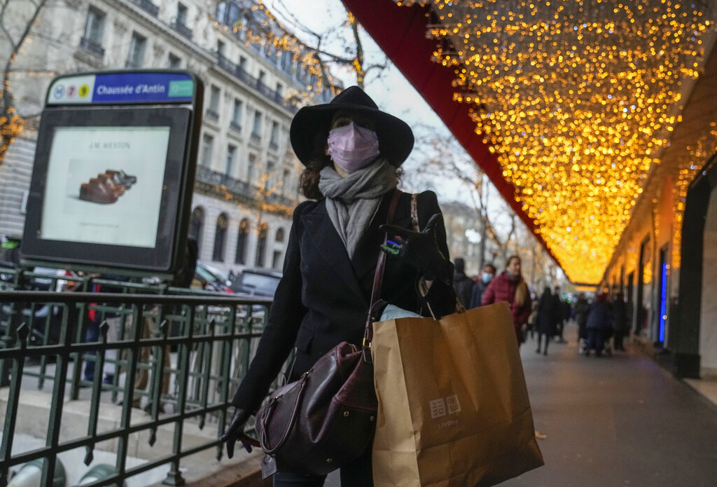 A woman wearing face mask to protect against COVID-19 shops in central Paris. France’s government is desperately trying to avoid a new lockdown that would hurt the economy