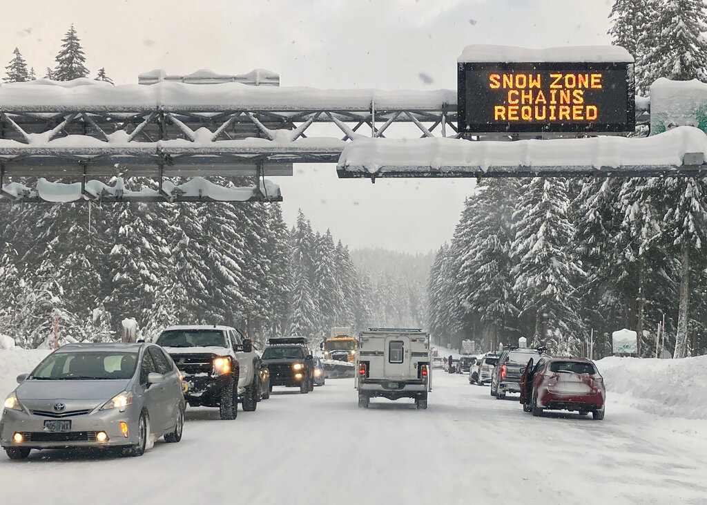 Heavy traffic is seen at the base of a snowy Santiam Pass in Detroit, Oregon, Sunday, Dec. 26, 2021.