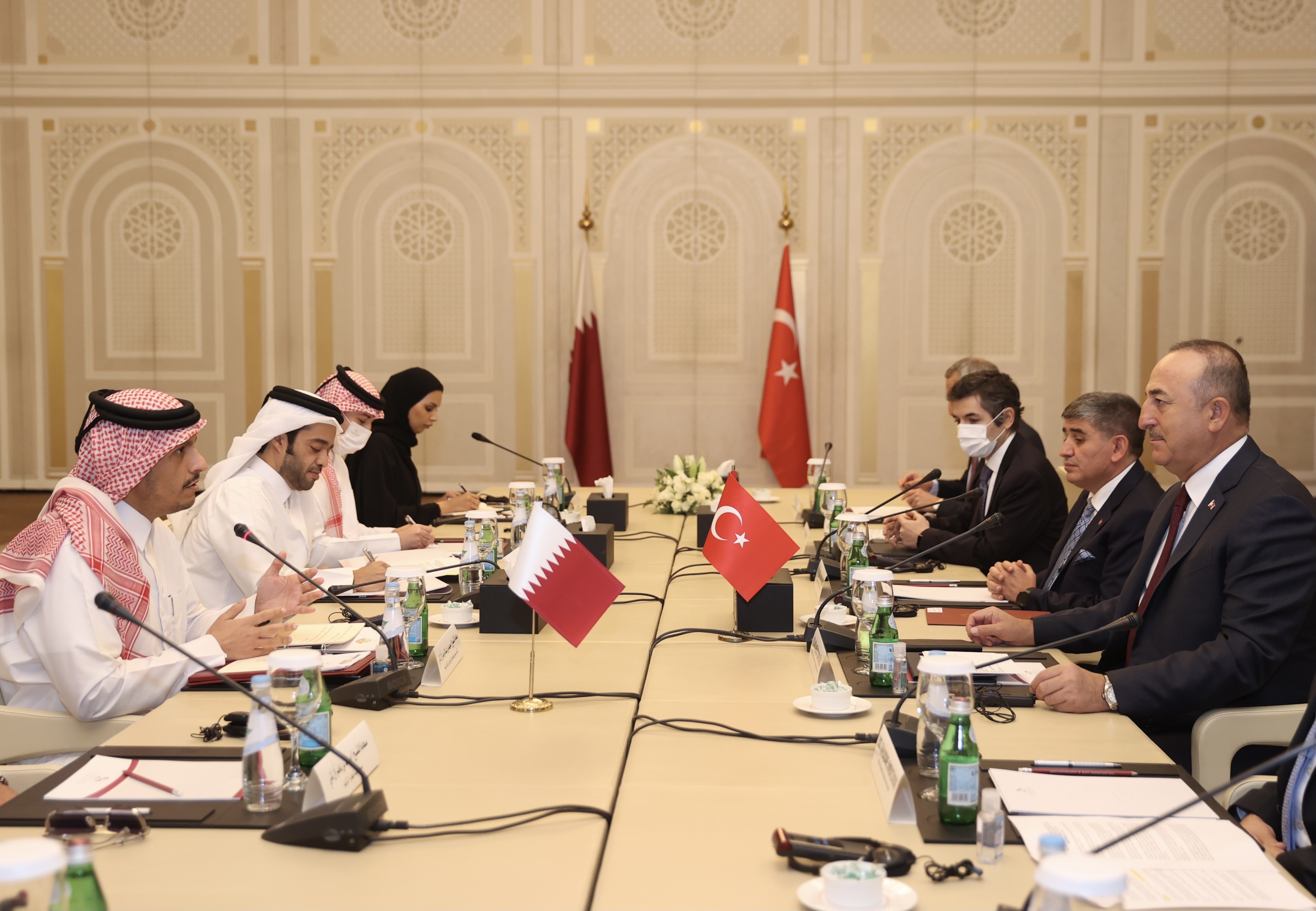Turkish Foreign Minister Mevlut Cavusoglu, right foreground, and Qatari Foreign Minister Sheikh Mohammed bin Abdulrahman Al Thani, left foreground, meeting in Doha