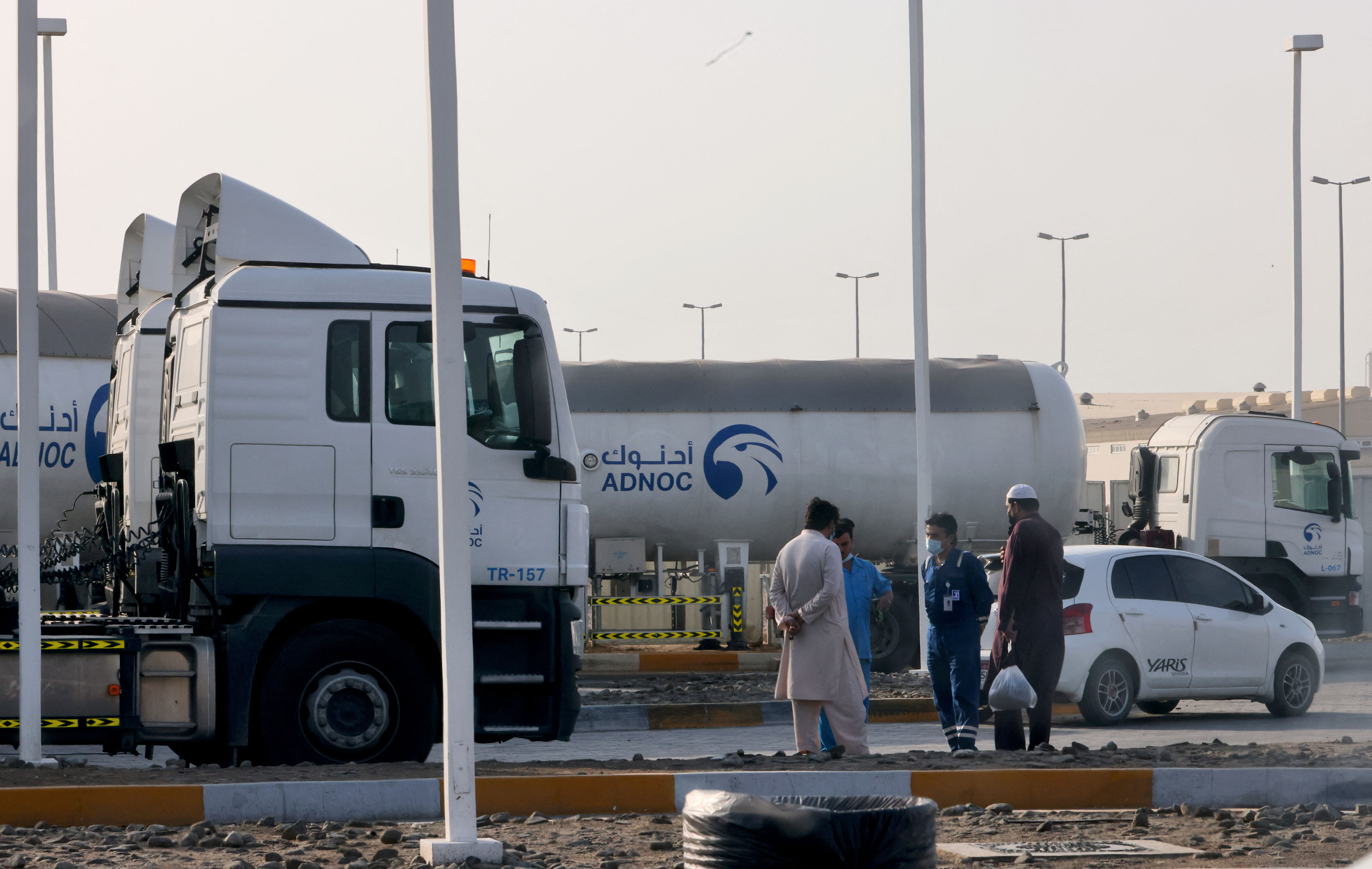 Men stand outside a storage facility of oil giant ADNOC in the capital of the United Arab Emirates, Abu Dhabi [AFP]