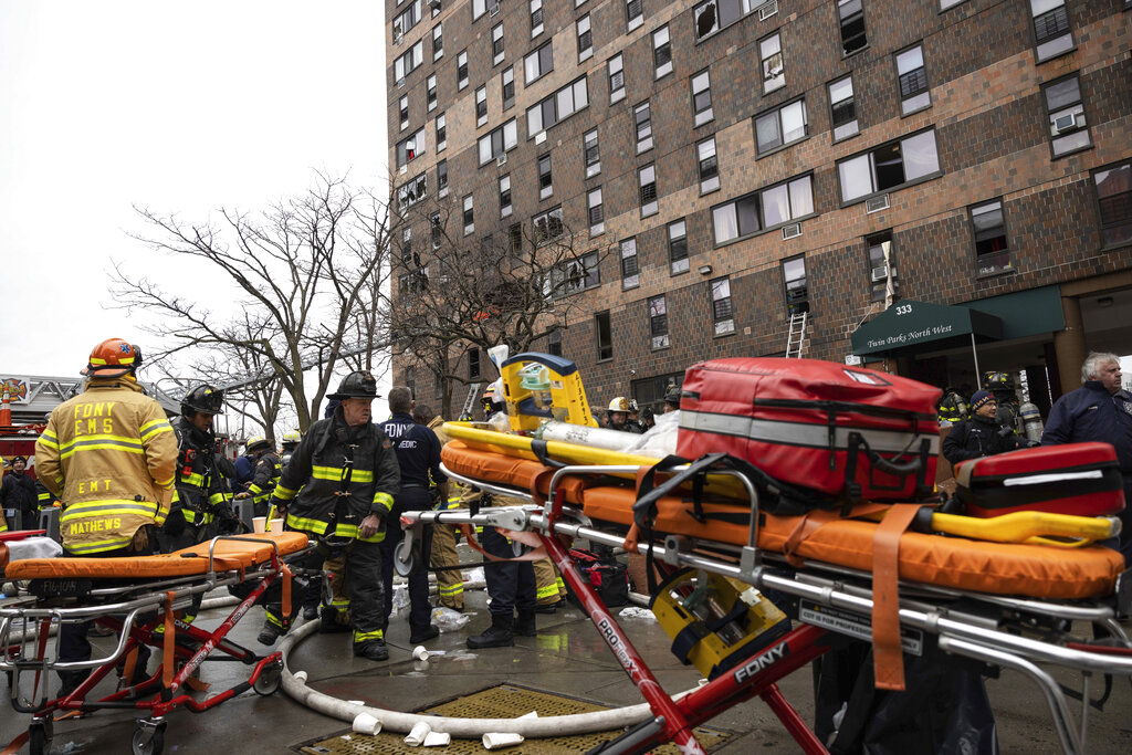 Firefighters work outside an apartment building after the deadly fire in the Bronx, New York, on January 9