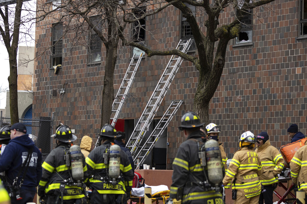 Ladders are seen erected beside the apartment building where at least 19 people died in a fire that started with a bedroom electric heater