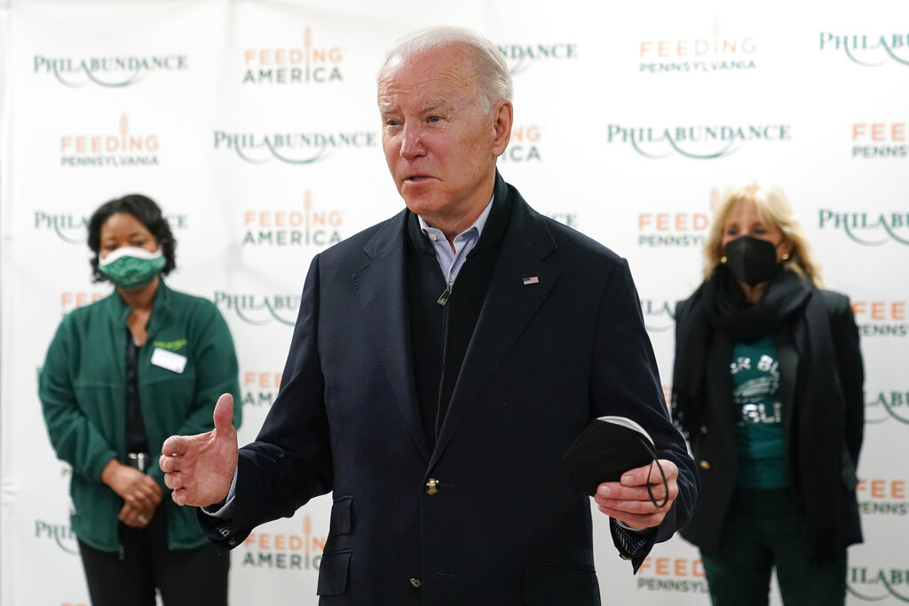 President Joe Biden speaks with members of the press about the Texas synagogue hostage incident before volunteering with first lady Jill Biden, back right, at hunger relief organization Philabundance.