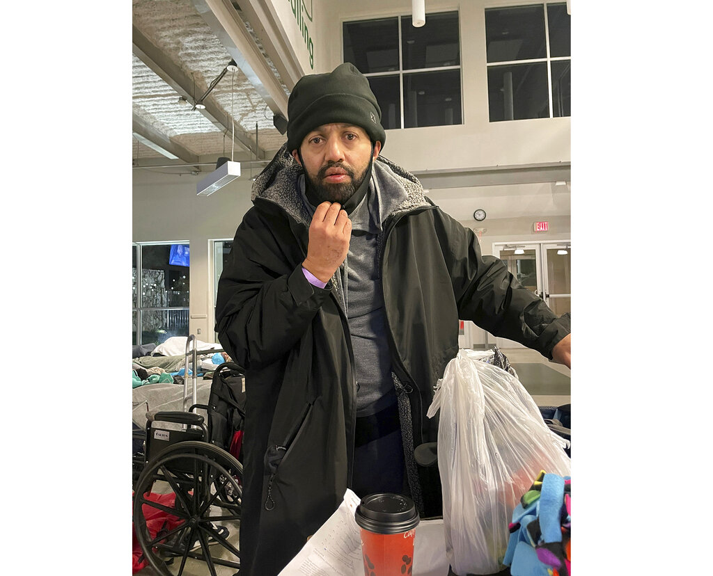Malik Faisal Akram, dressed in a winter coat and hat, is seen at a Dallas homeless shelter.