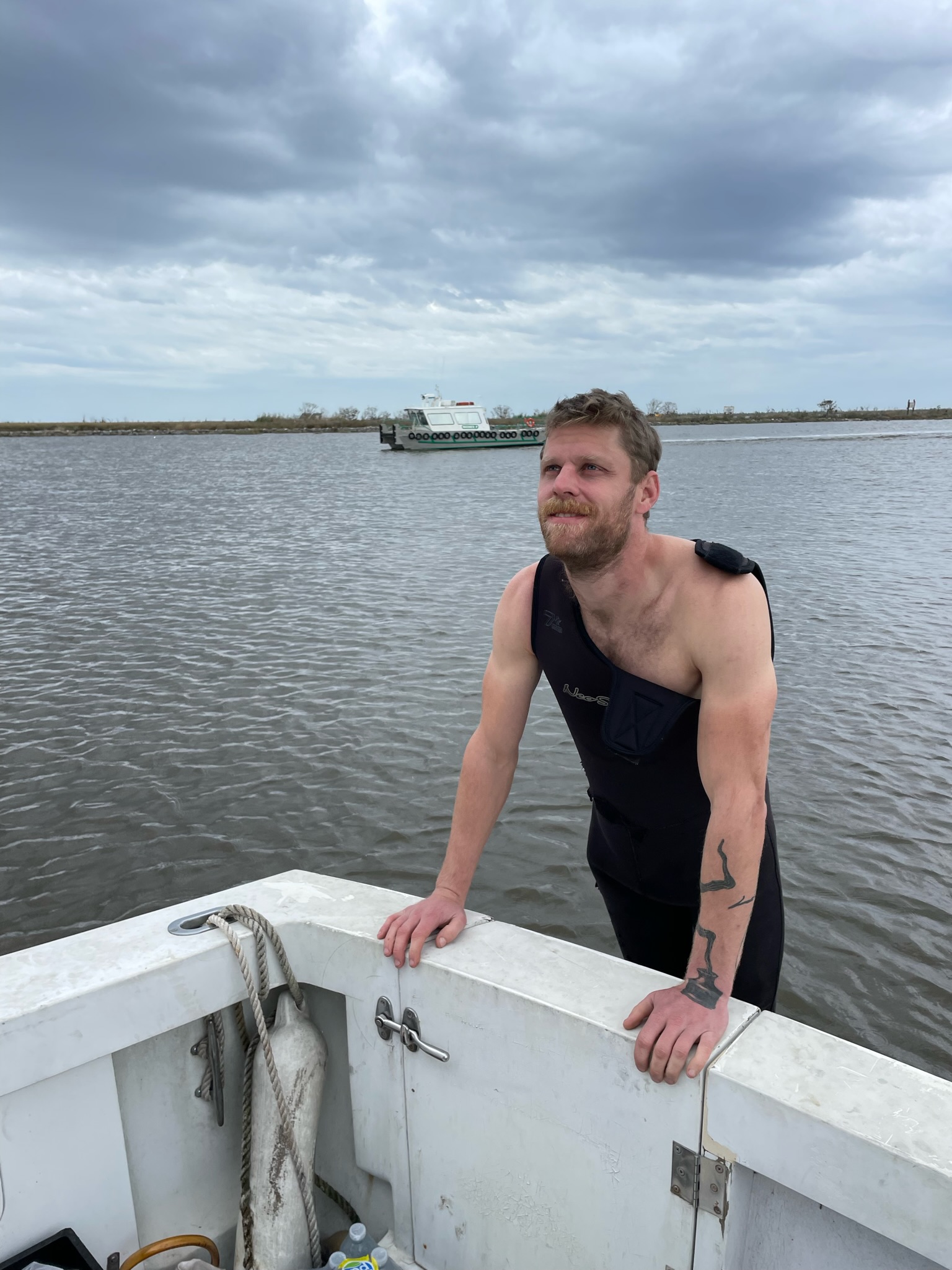 Luke LaCava prepares to jump into the bayou to check for damage to the propellor after Les Bons Temps struck something in the shallow water