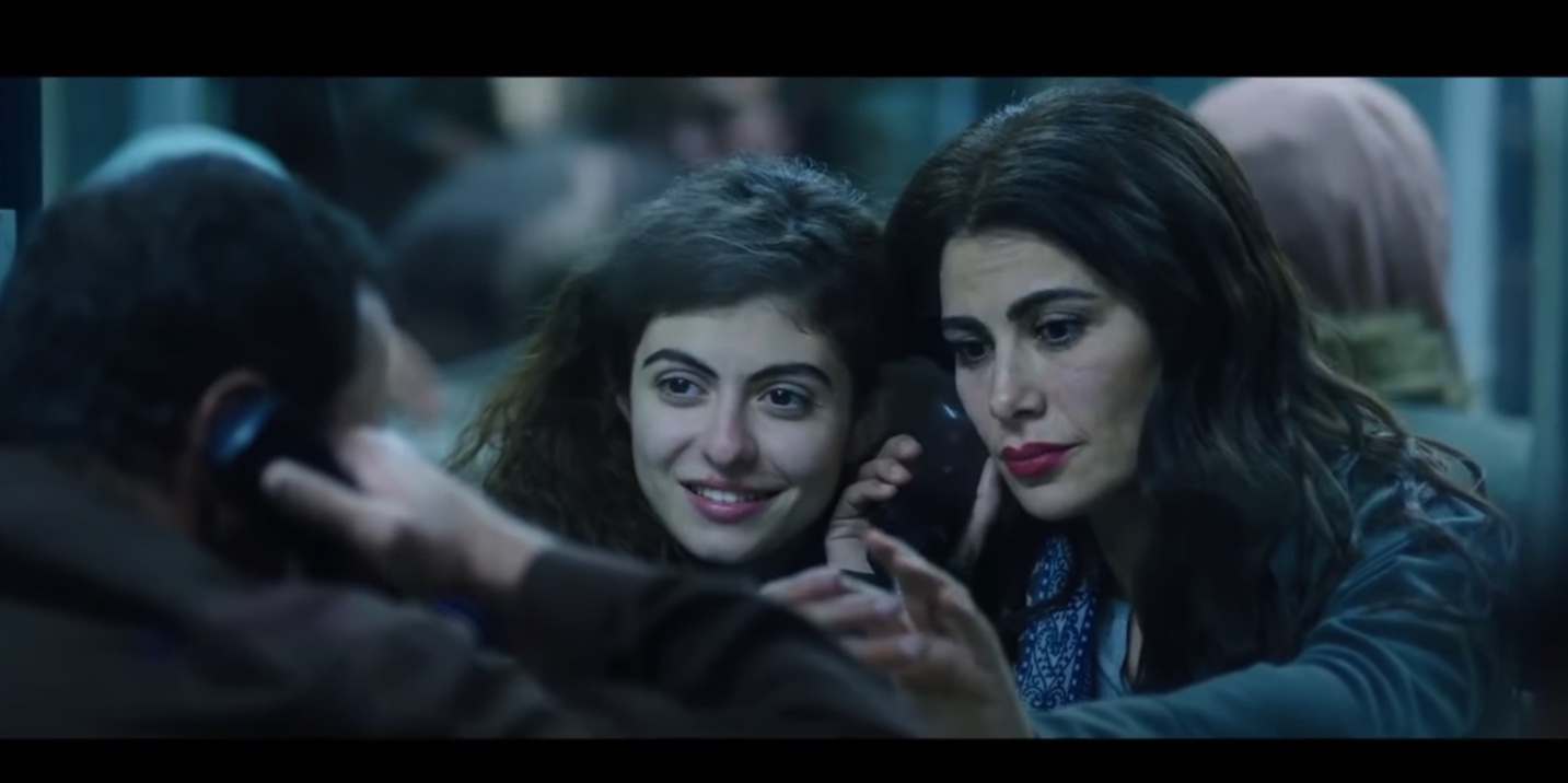 In a scene from the film Amira, two women seen talking to an incarcerated man on the phone
